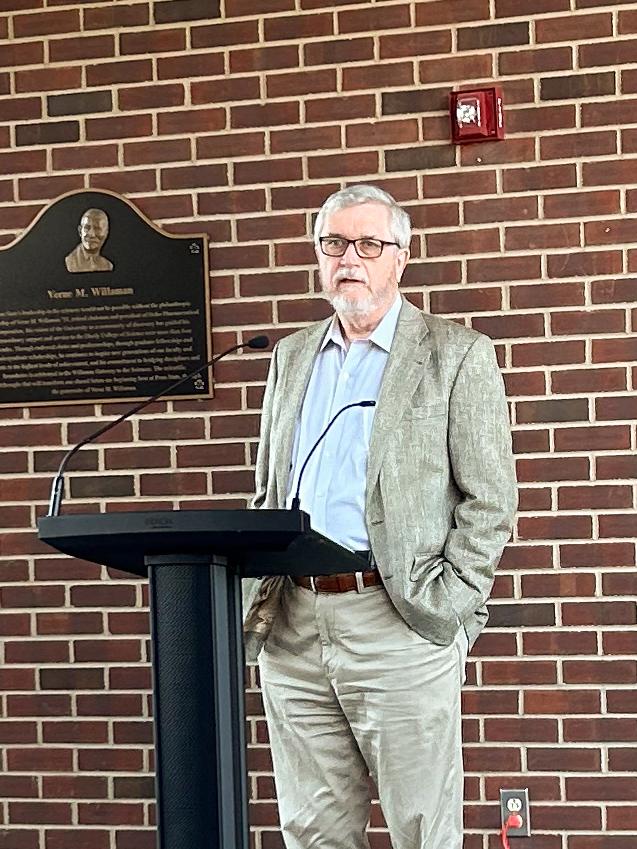 John Golbeck speaking in front of a podium.