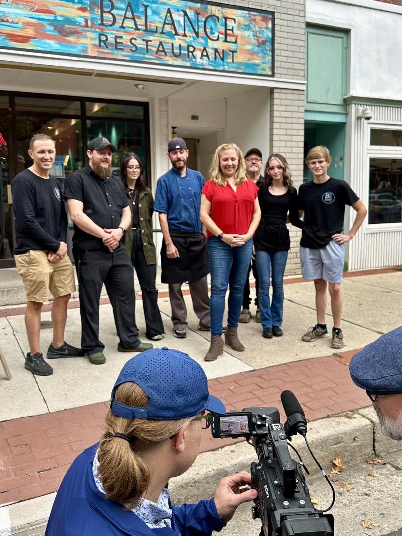 People posing for a photo in front of a restaurant.