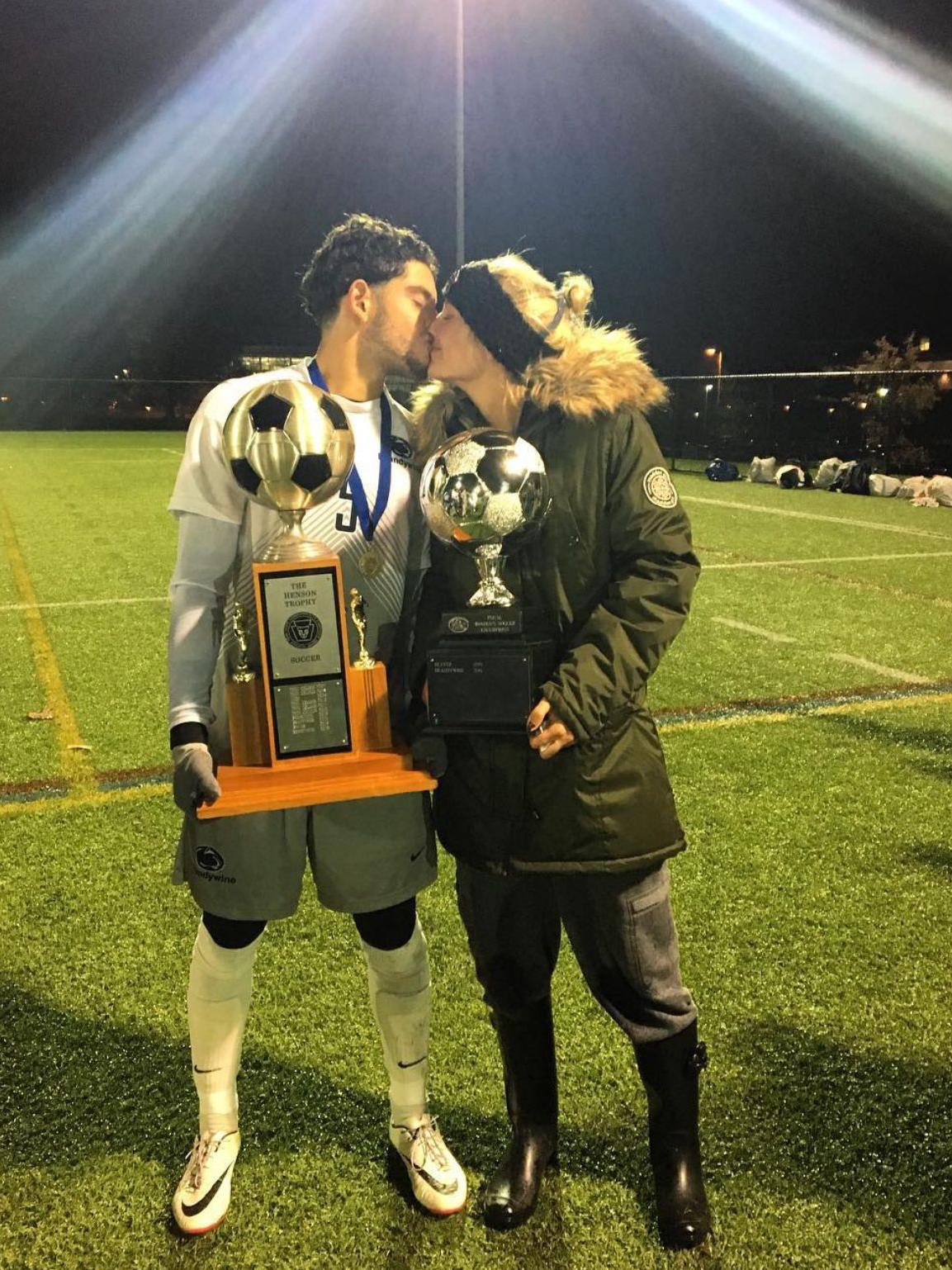 esteban and ami kissing while holding trophies