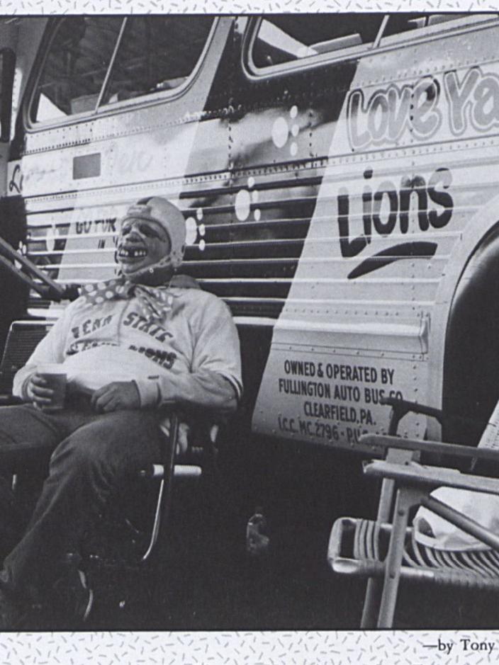 A person wearing a mask sits in a chair outside of a bus