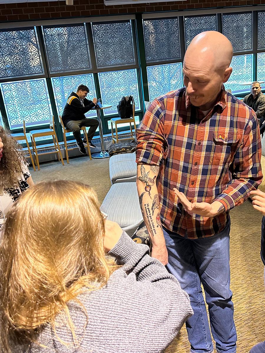 Students and faculty admire Professor Jeffery Stoyanoff's new tattoos.