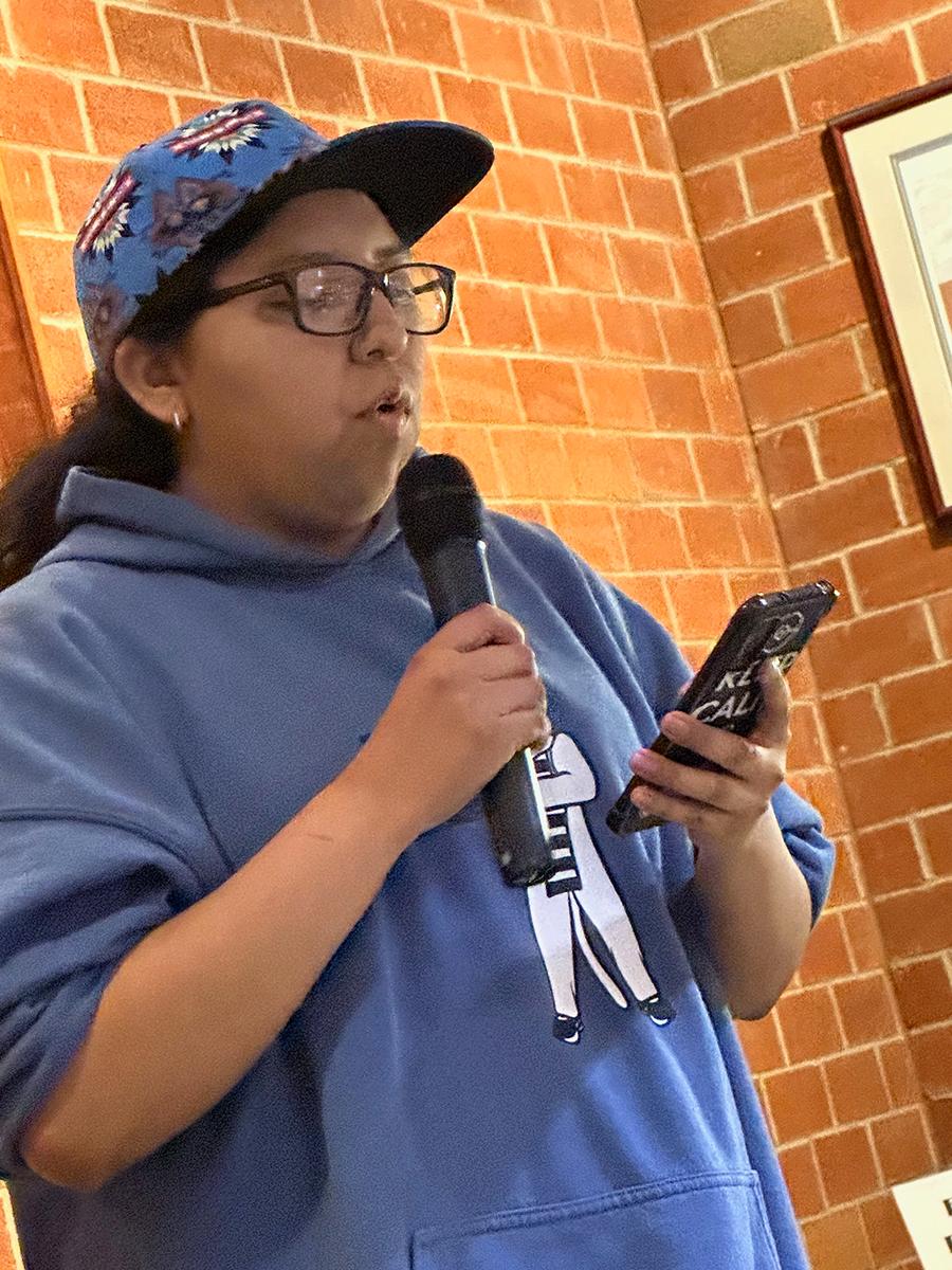 Student Alayna Mark reads an original poem.