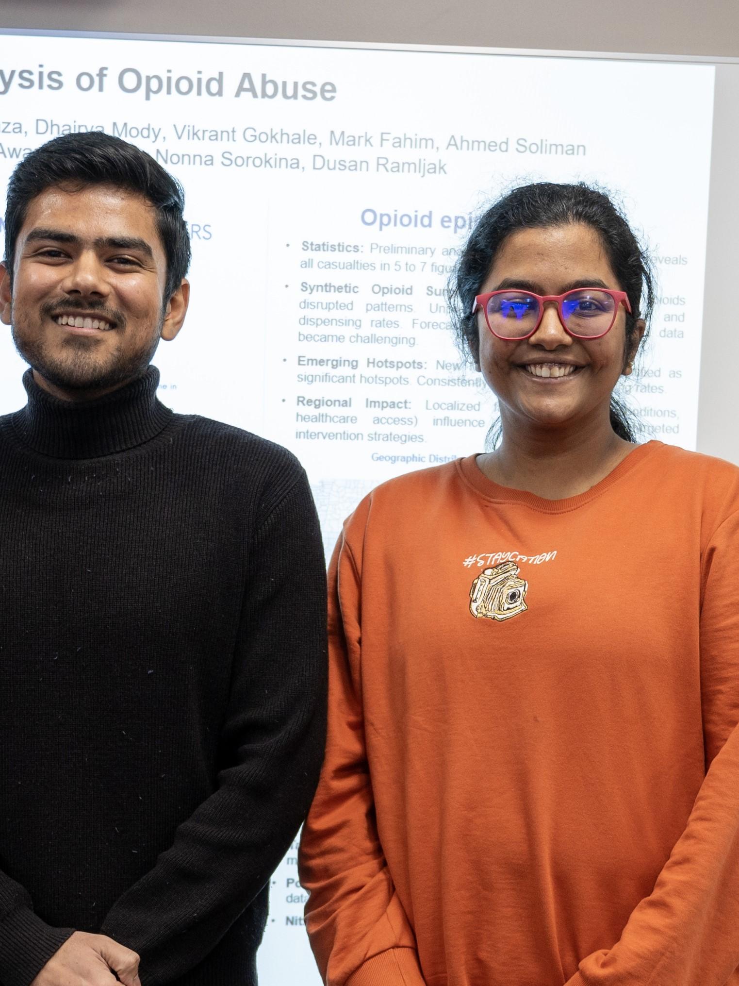 Data analytics students stand in front of their poster about a data-driven response to the opioid epidemic