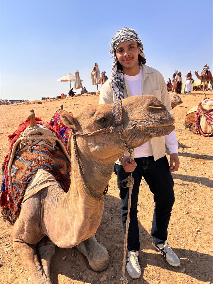 A student poses next to a camel 