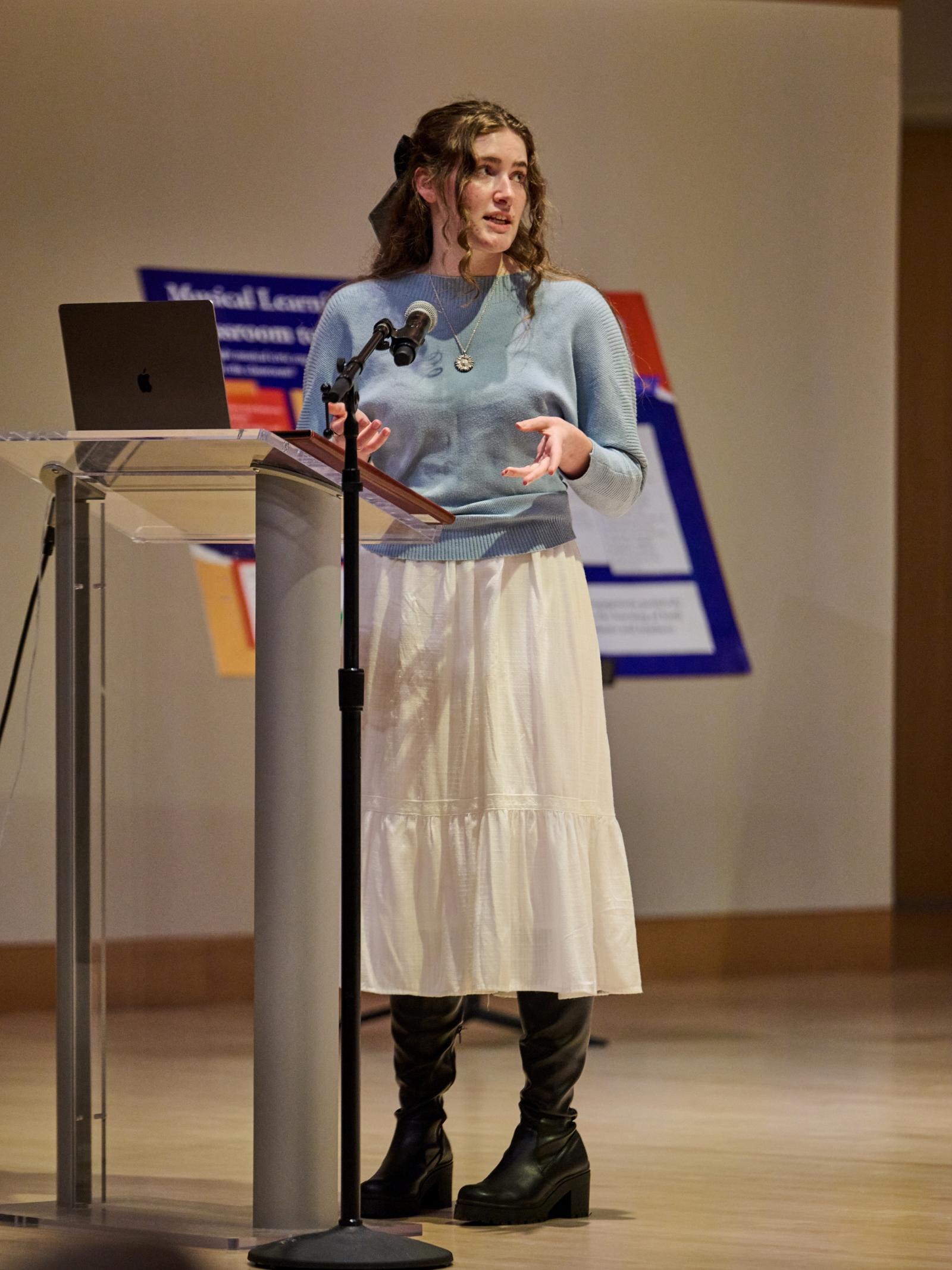 Student standing at podium on Recital Hall stage