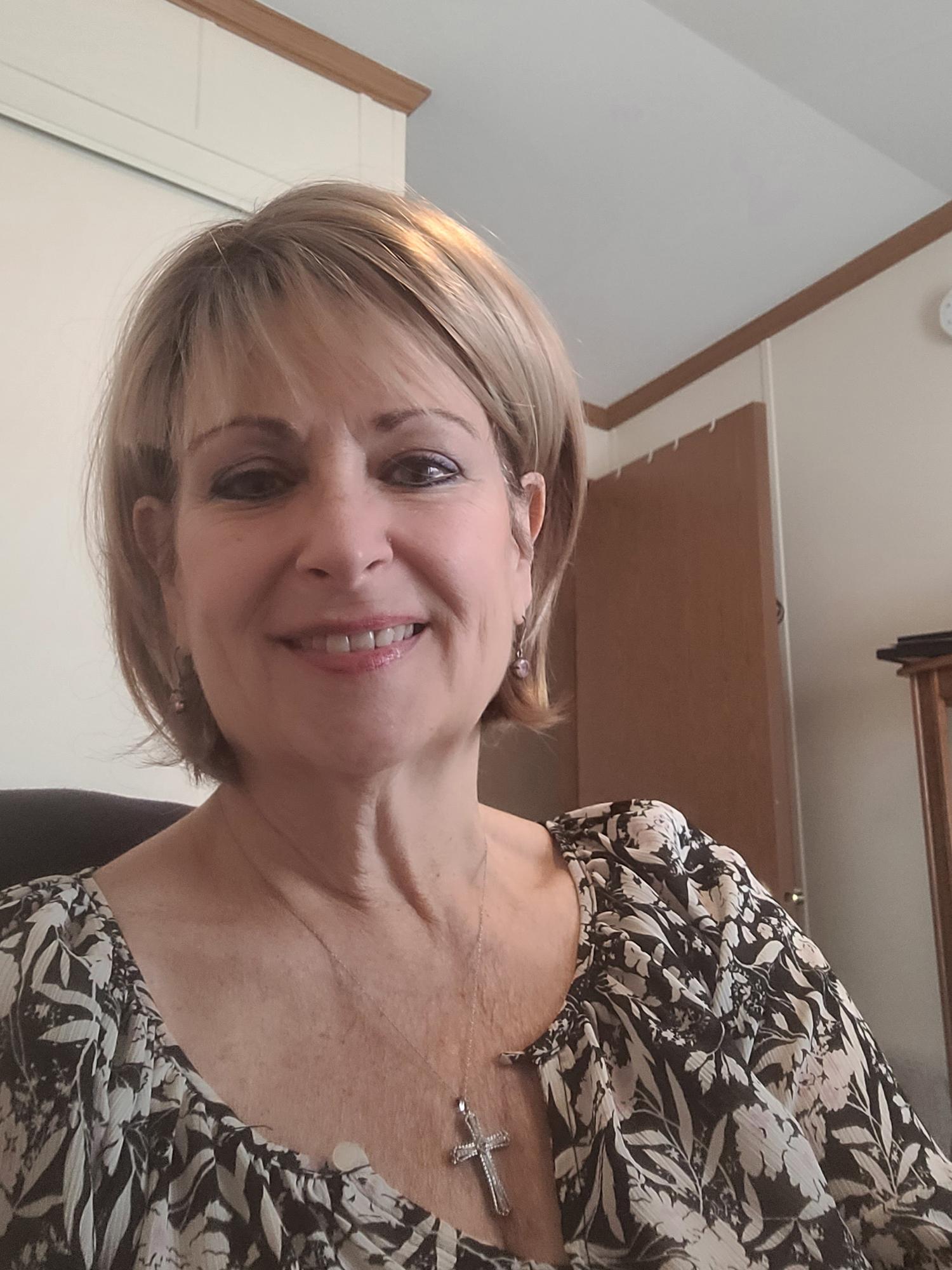 A woman with short blonde hair smiles at the camera.