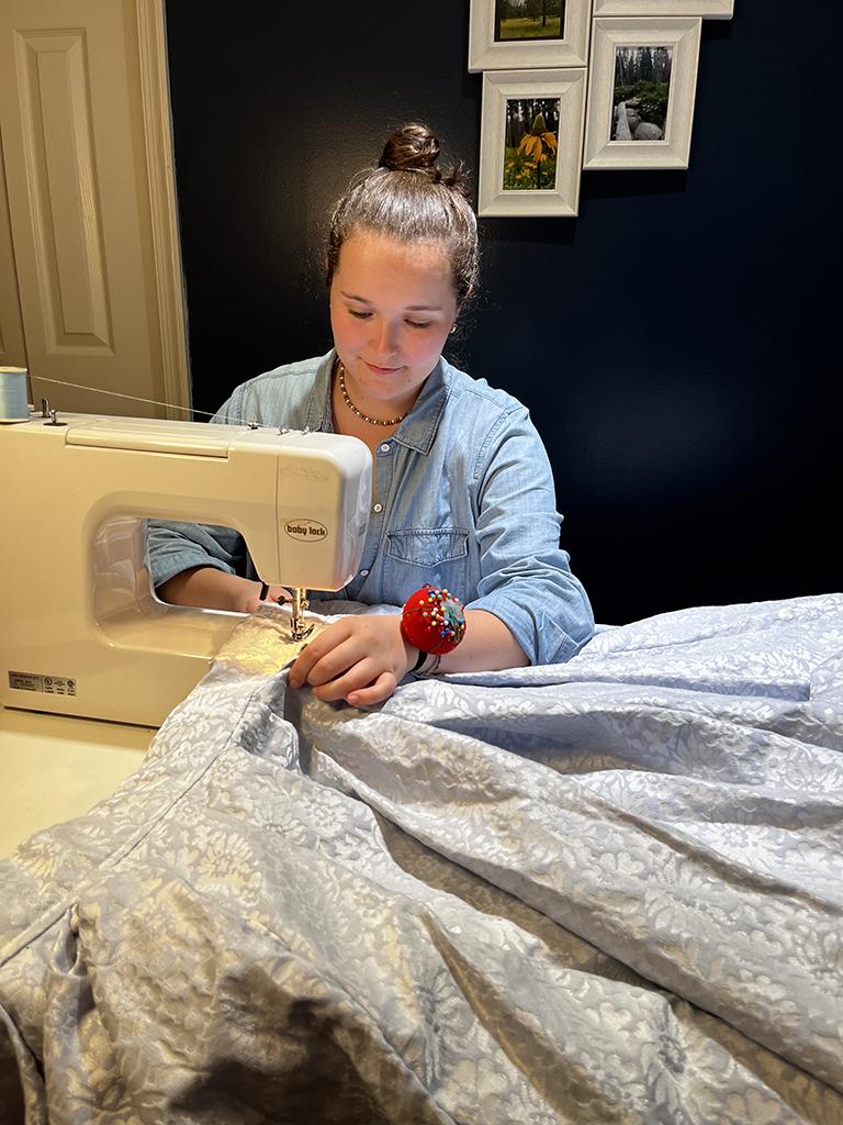 Penn State undergraduate student Irena Potochny sews a skirt from her great-grandmother's fabric collection. Potochny wore the skirt to her sustainable fashion show, Conscious Couture.