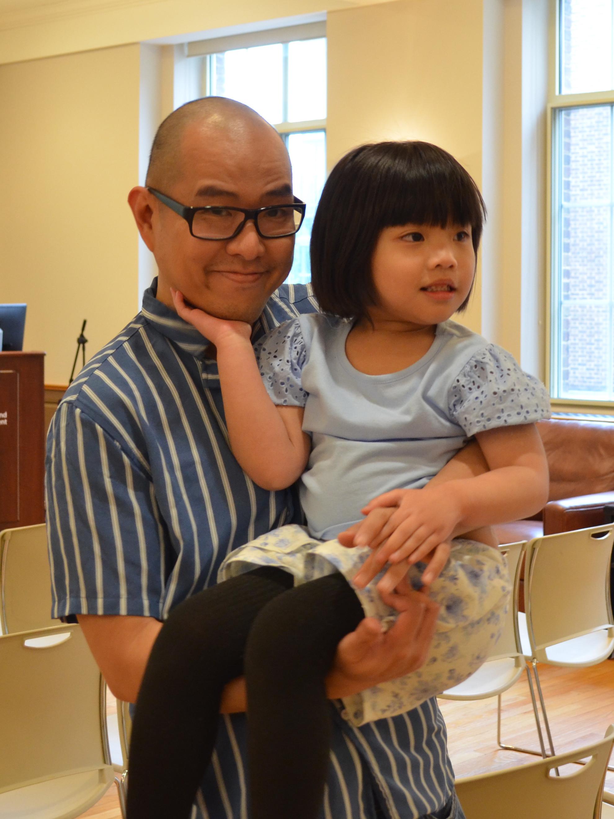 Mark Ramos holds his duaghter Mabel in a room on Penn State University Park campus