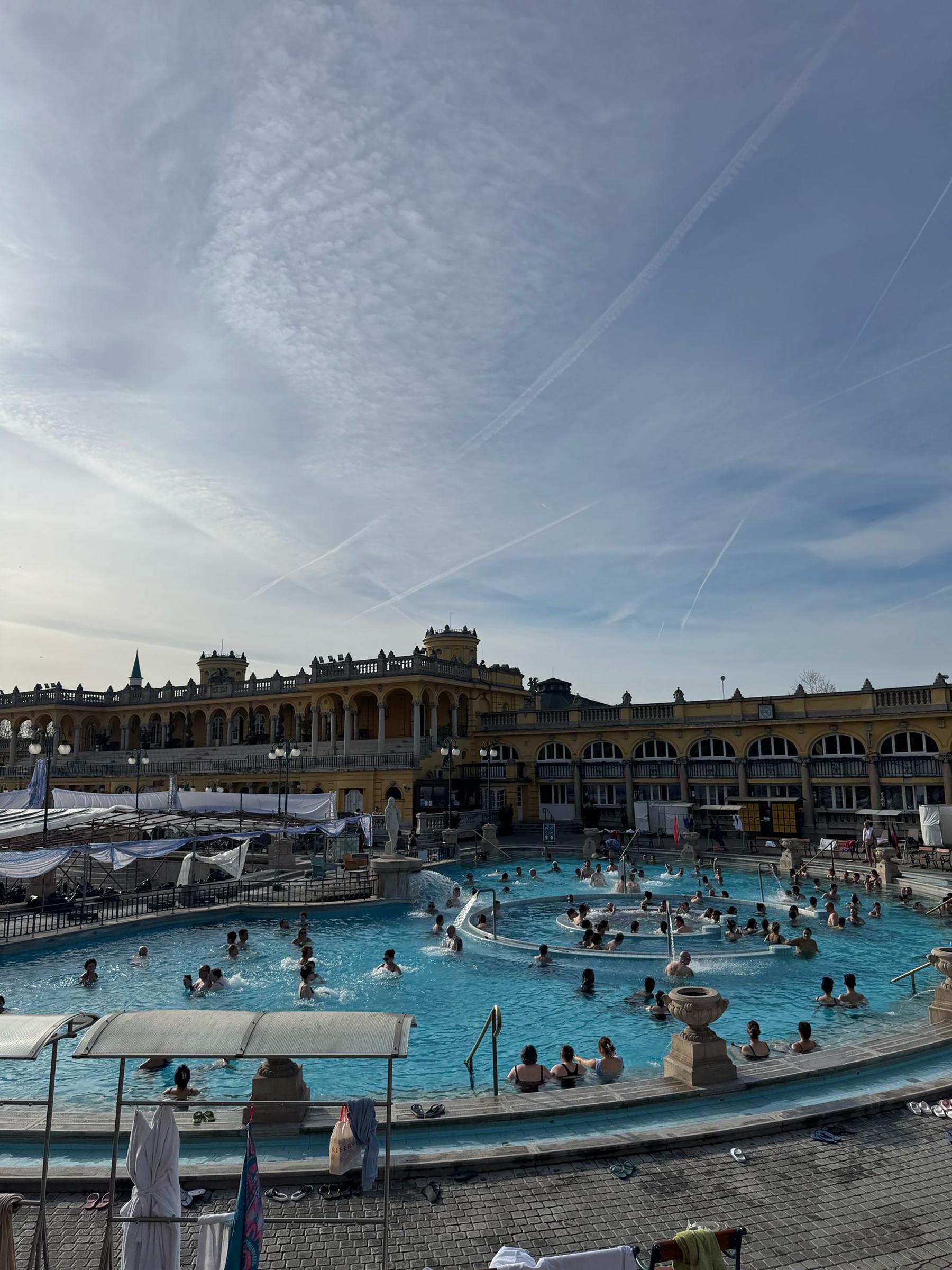 A large swimming pool with old-style European architecture.