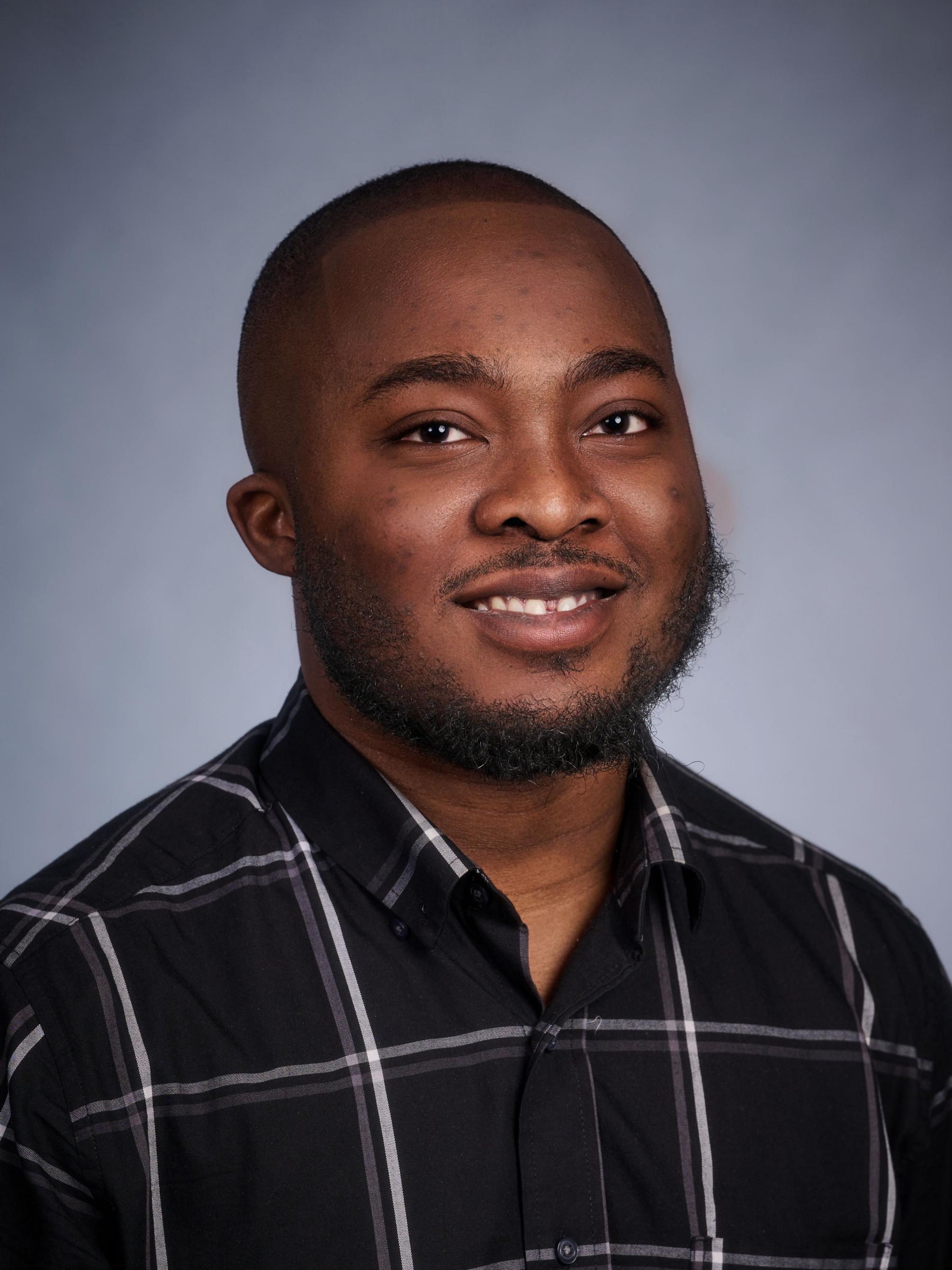 Edwin Dartey wears a dark striped shirt 
