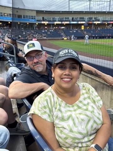 A man and a woman sitting at a baseball game
