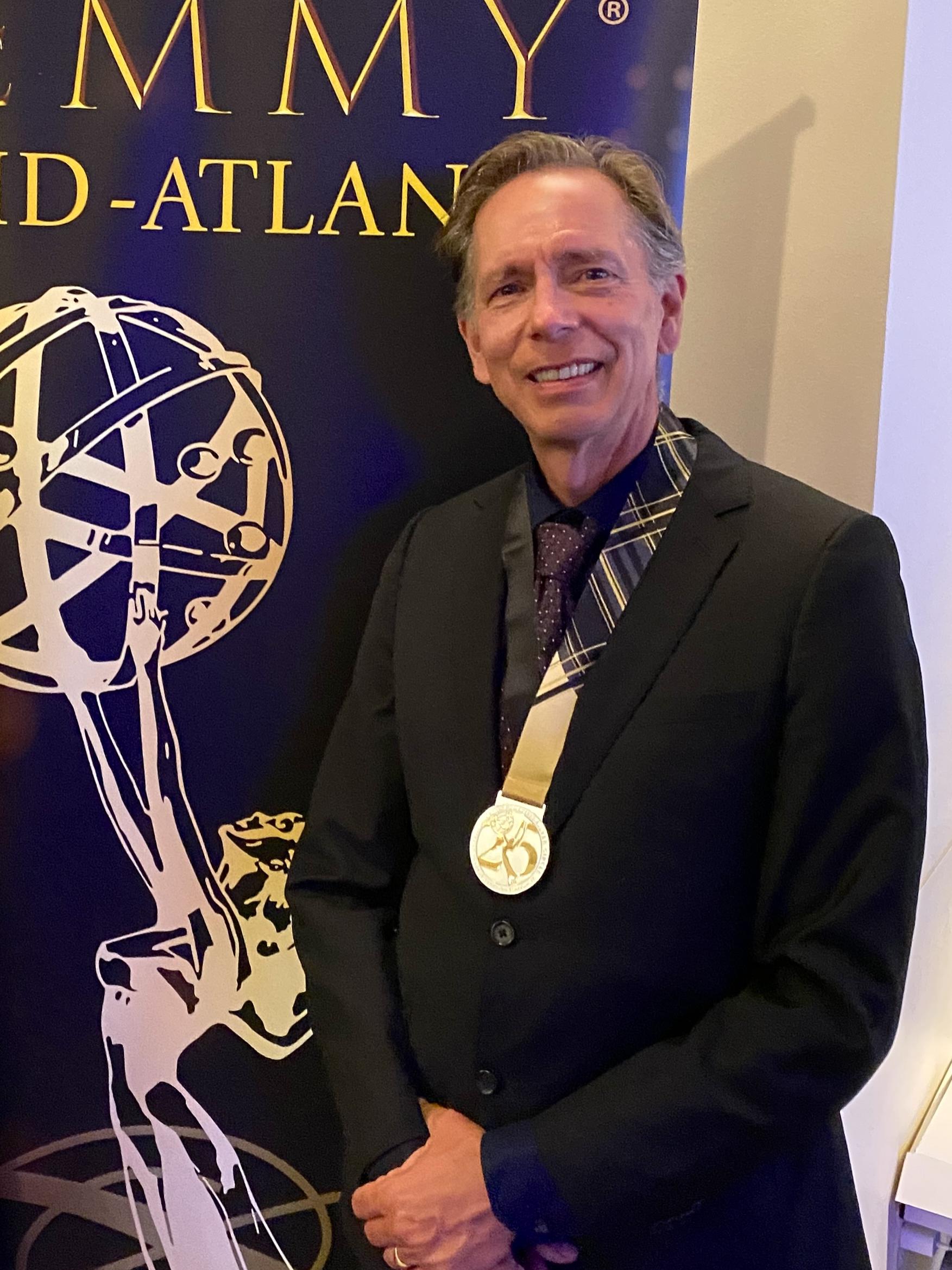 Man wearing a medallion posing for a photo.