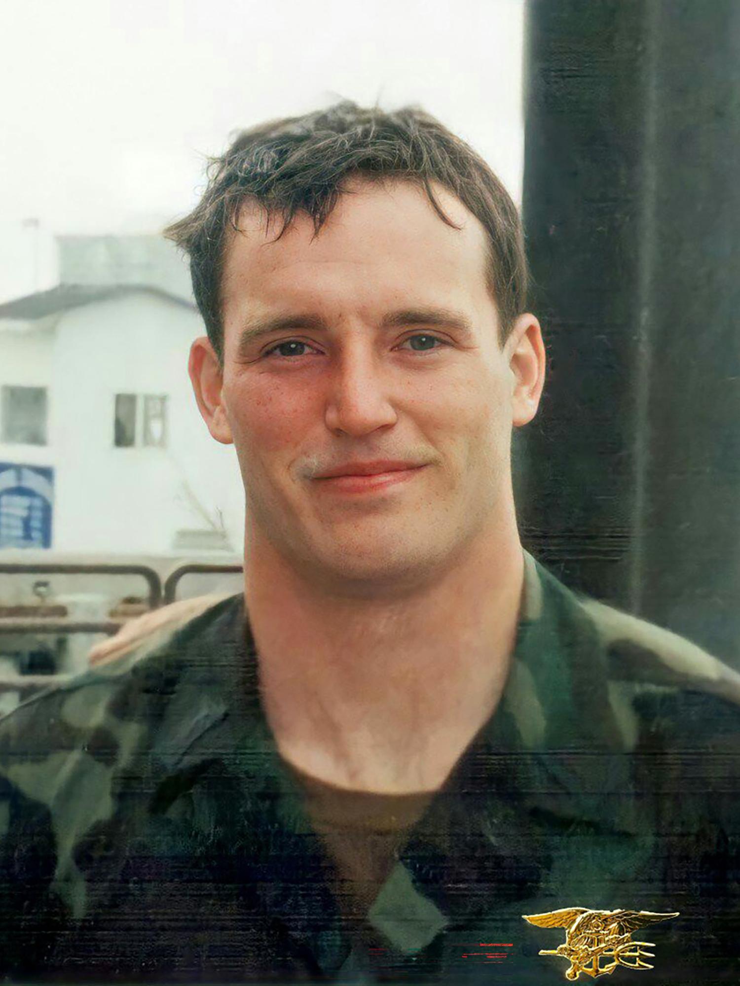 A man wearing a camouflaged military uniform.