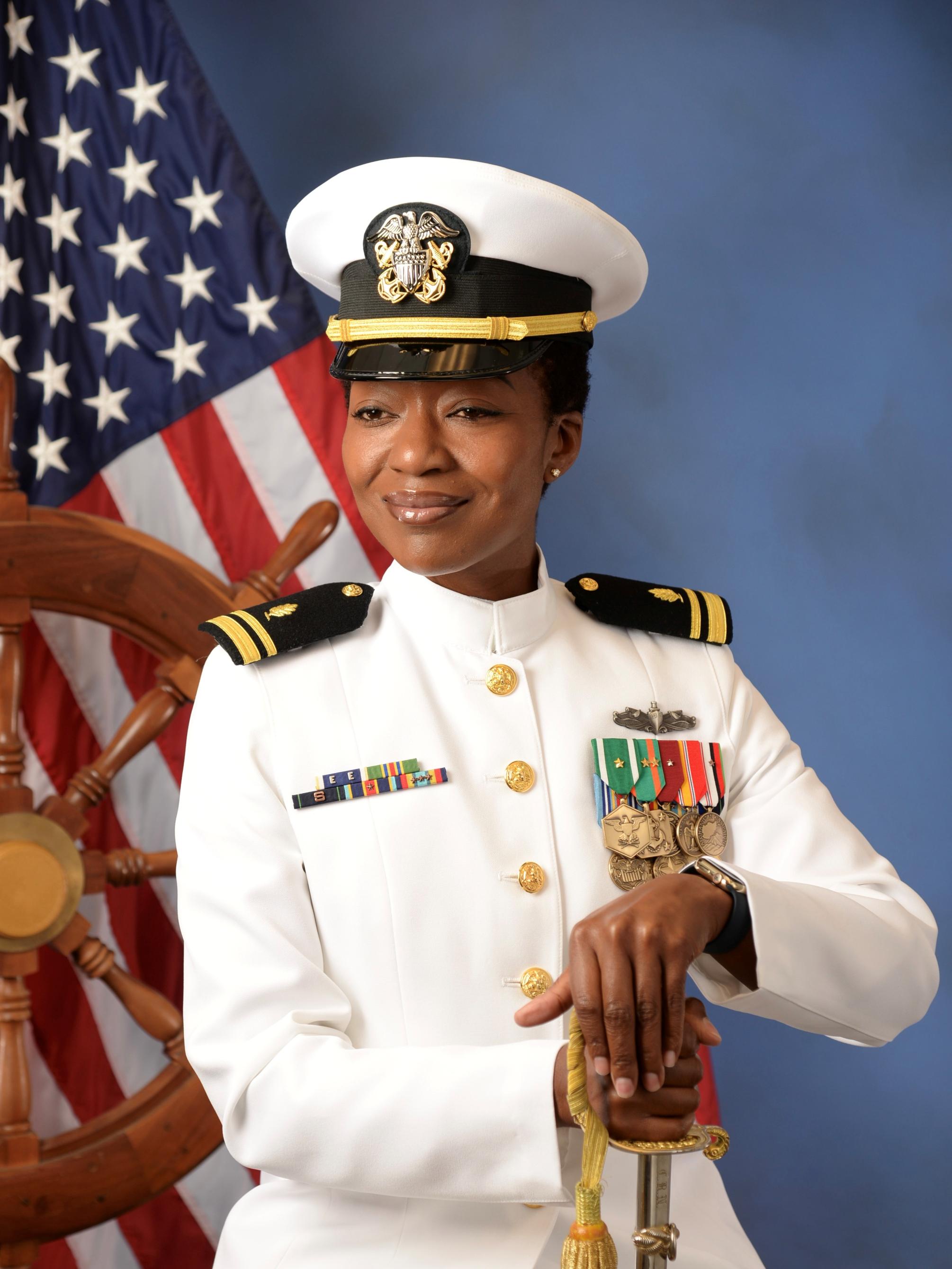 a woman in a sailor uniform with a US flag in the background