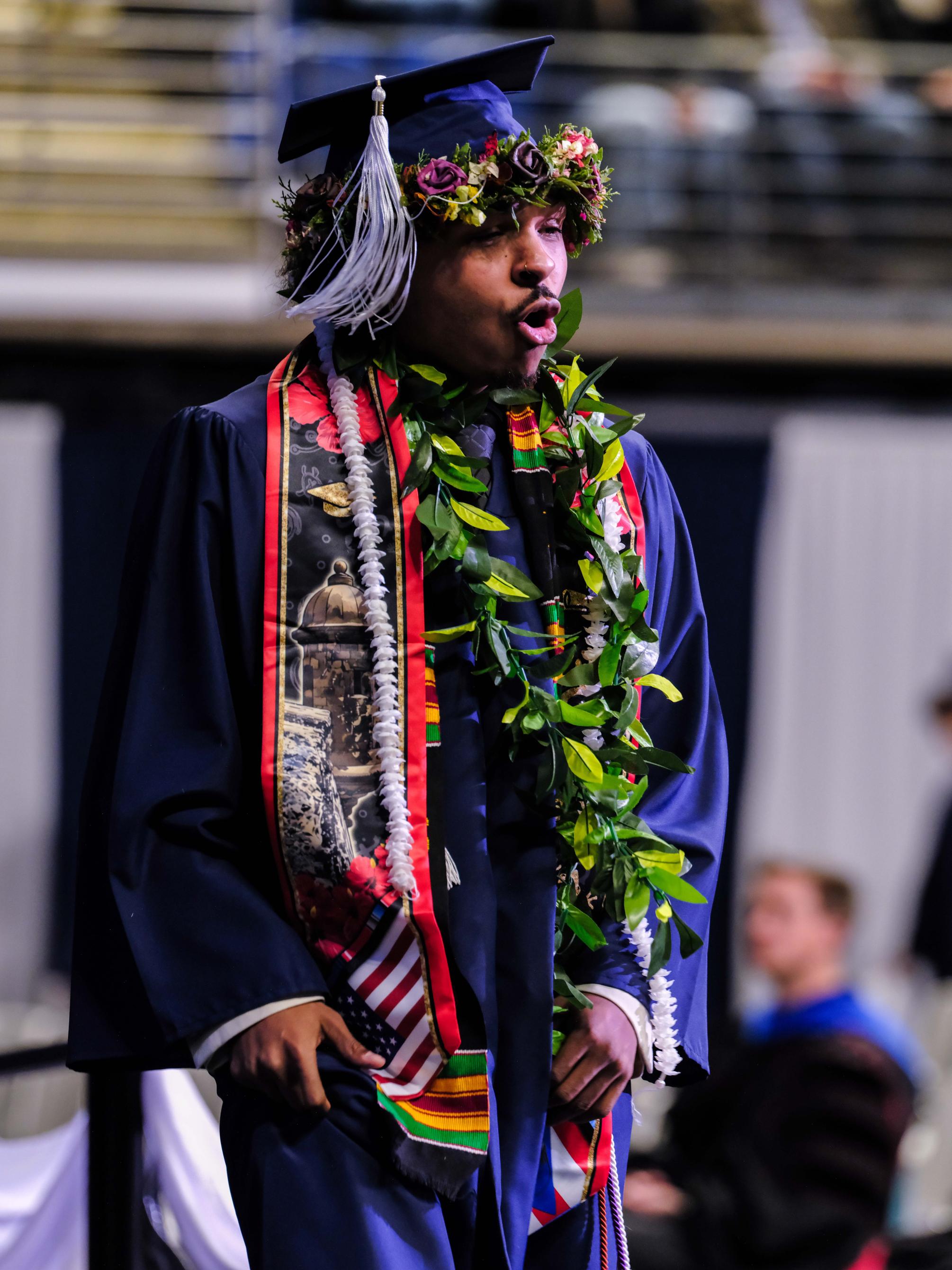 A student celebrates as he walks across the stage at graduation ceremony.