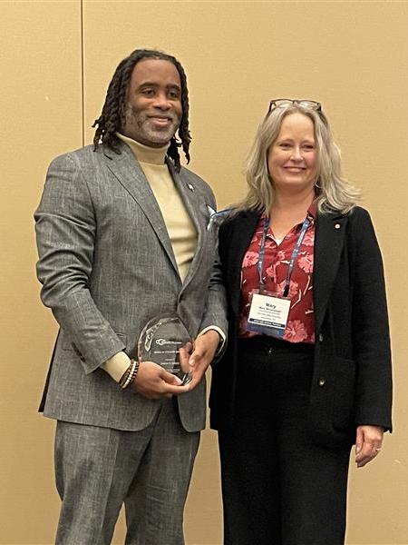 Levon Esters stands with Mary Stromberger, (title...), after receiving the Debra W. Stewart award from the Council of Graduate Schools.