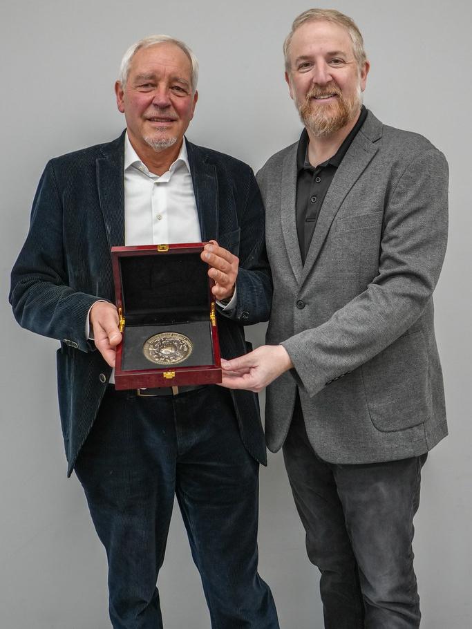 Thomas Bosch and Seth Bordenstein stand holding the Microbiome Medal.