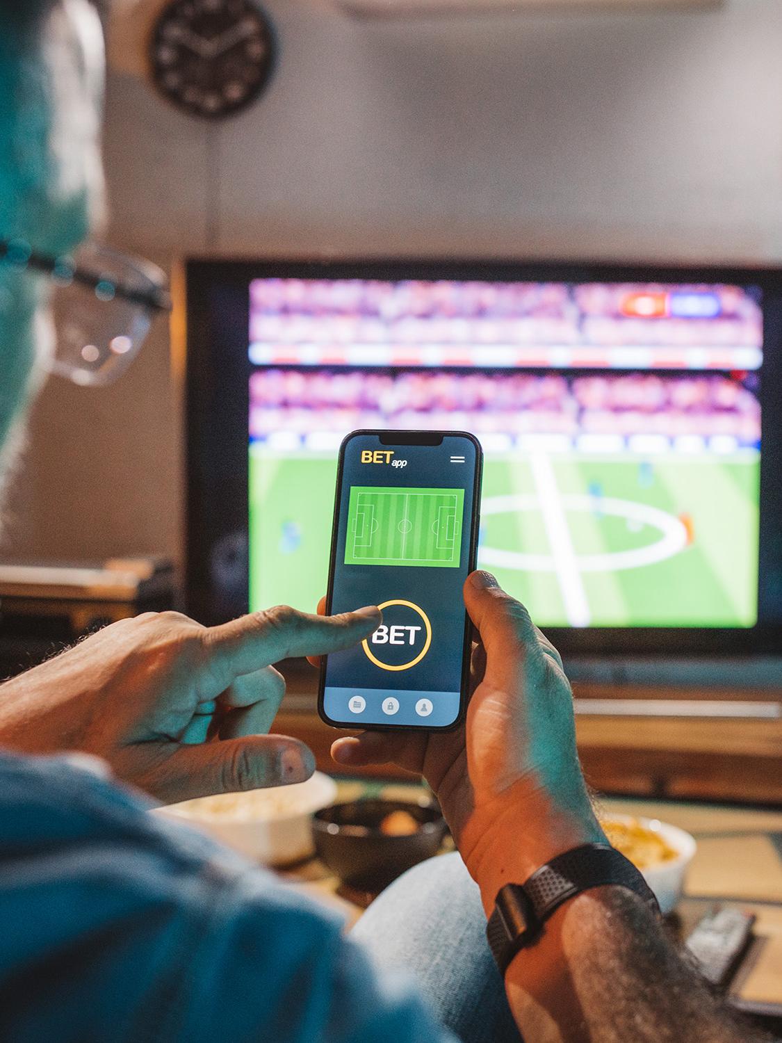 Person holding a phone in front of a television