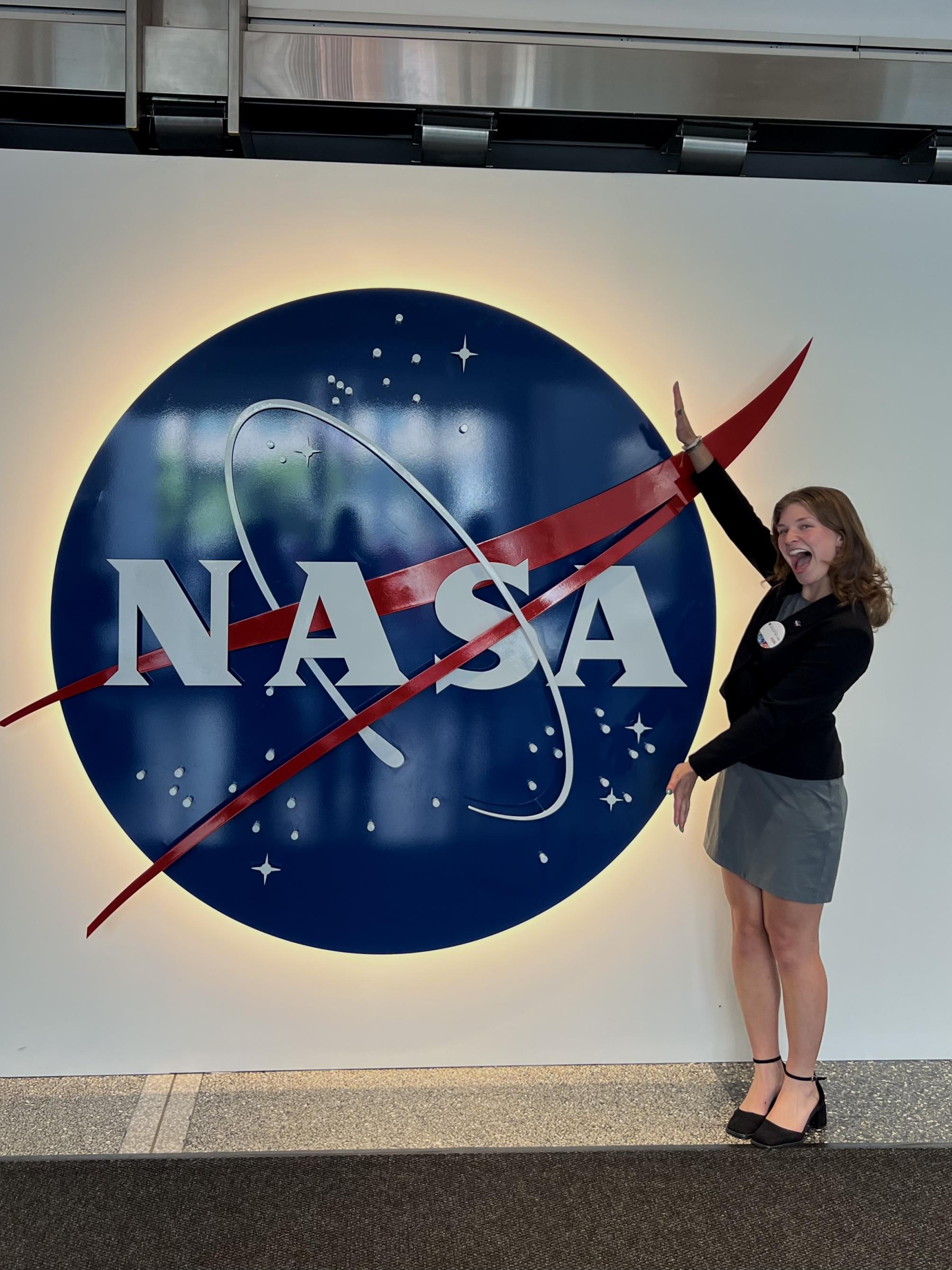 A student poses in front of the NASA sign