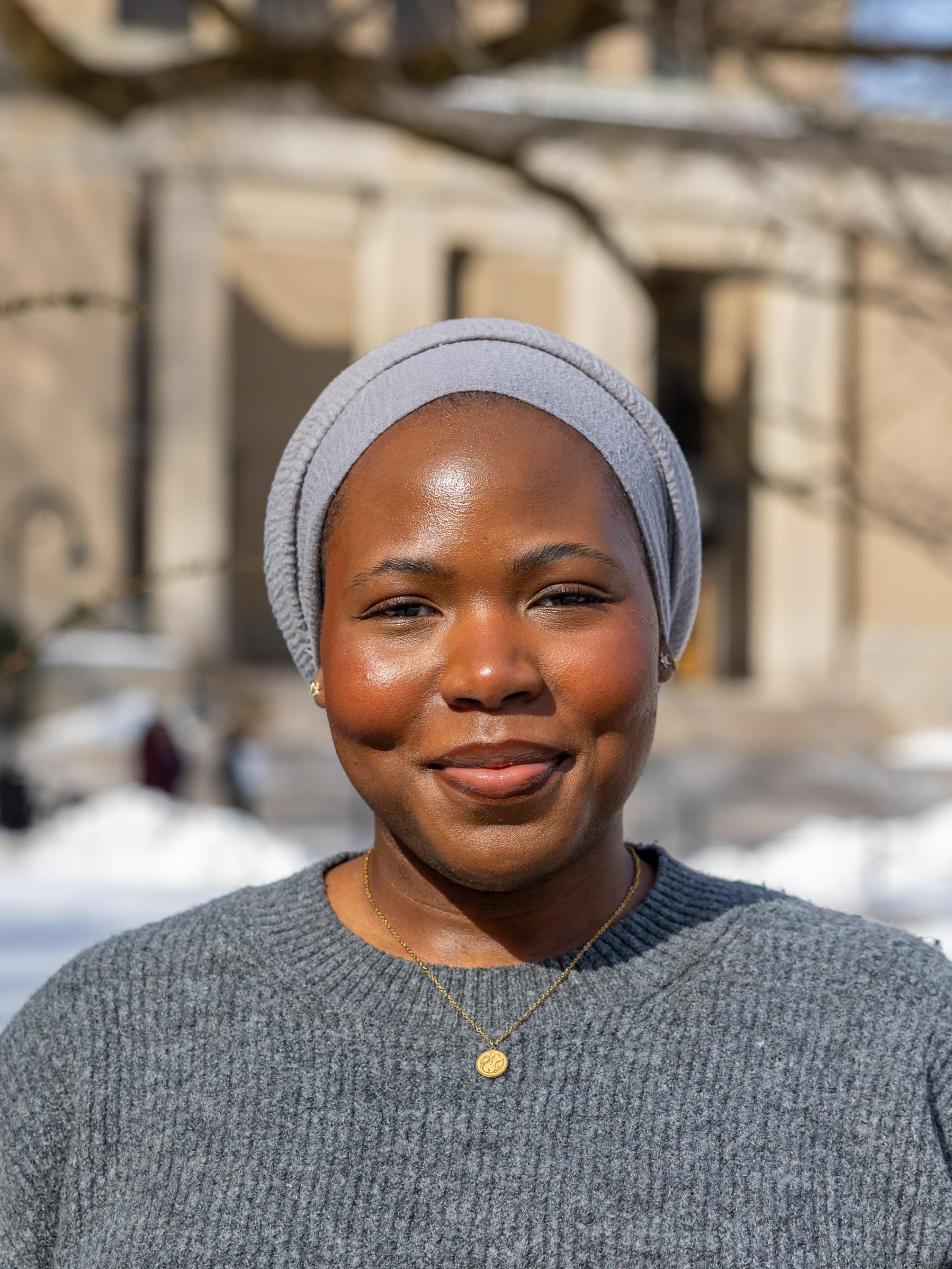 Safiya Haruna stands in front of Pattee and Paterno Libraries on a snowy day.
