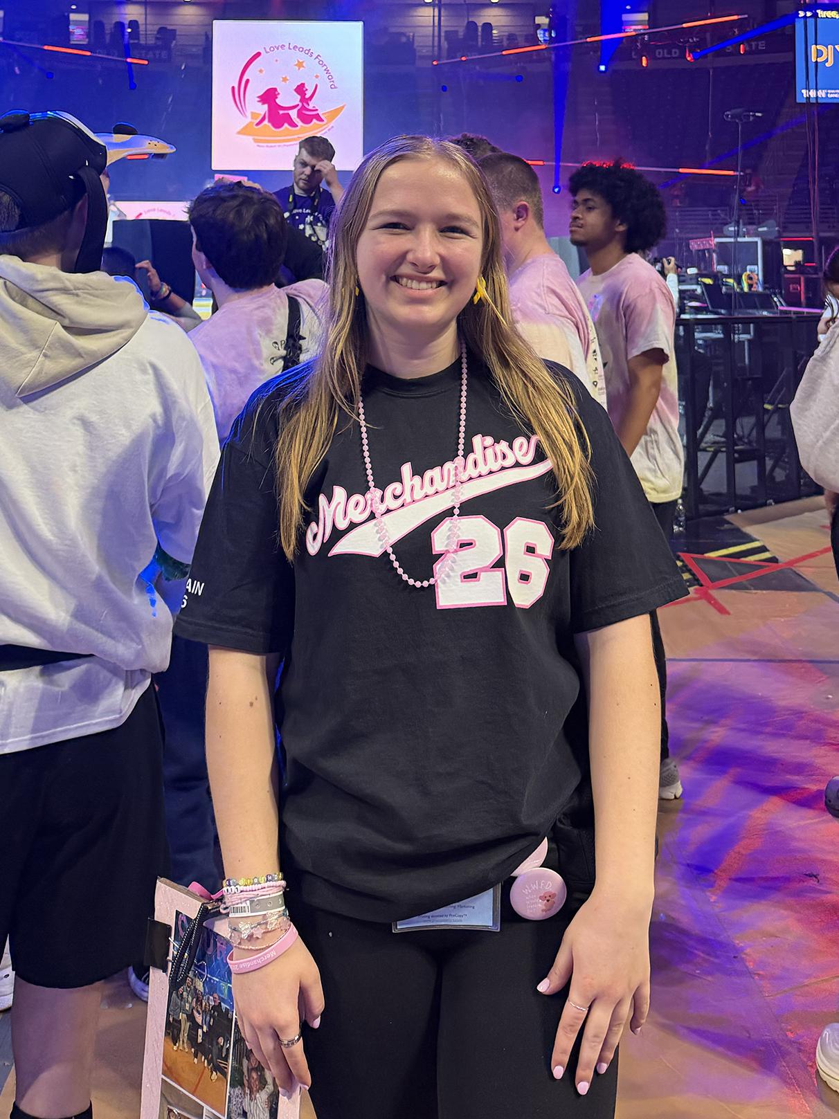 A photo of a smiling Courtney Lamelza on the floor of the Bryce Jordan Center during THON.