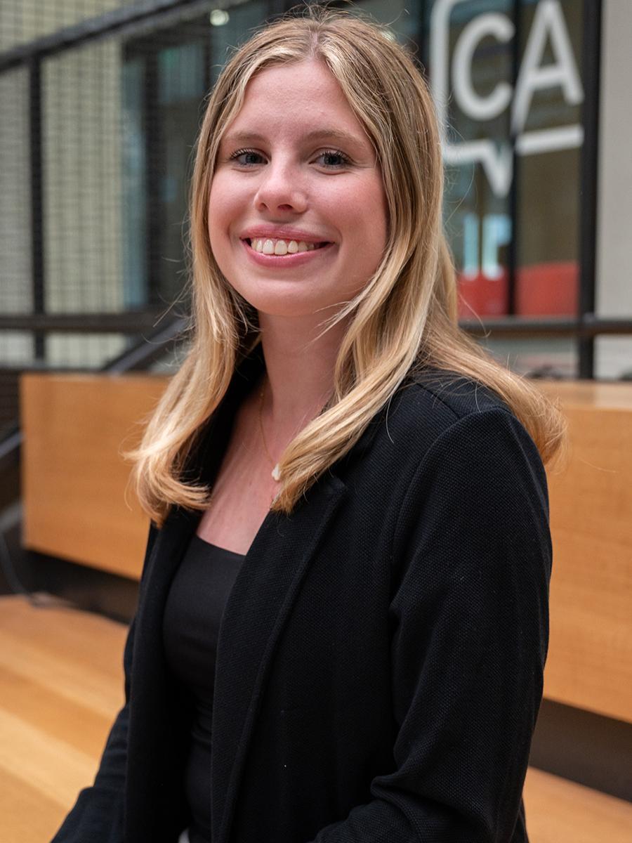 Smiling blondhaired woman wearing a dark suit coat