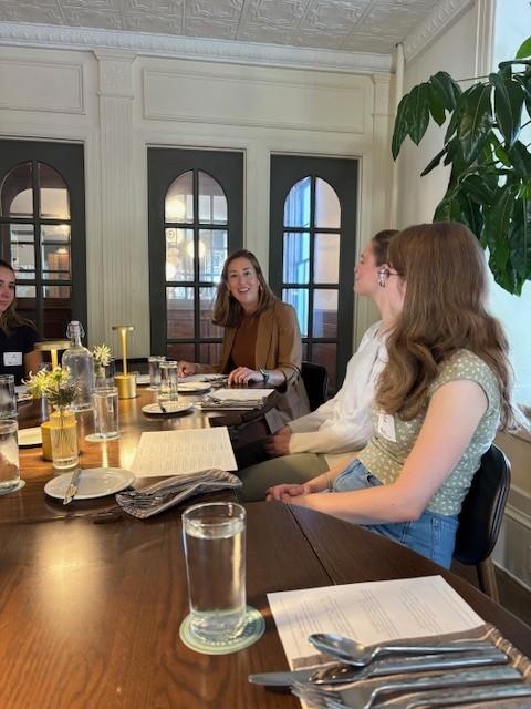 People talk around a table with food and drink