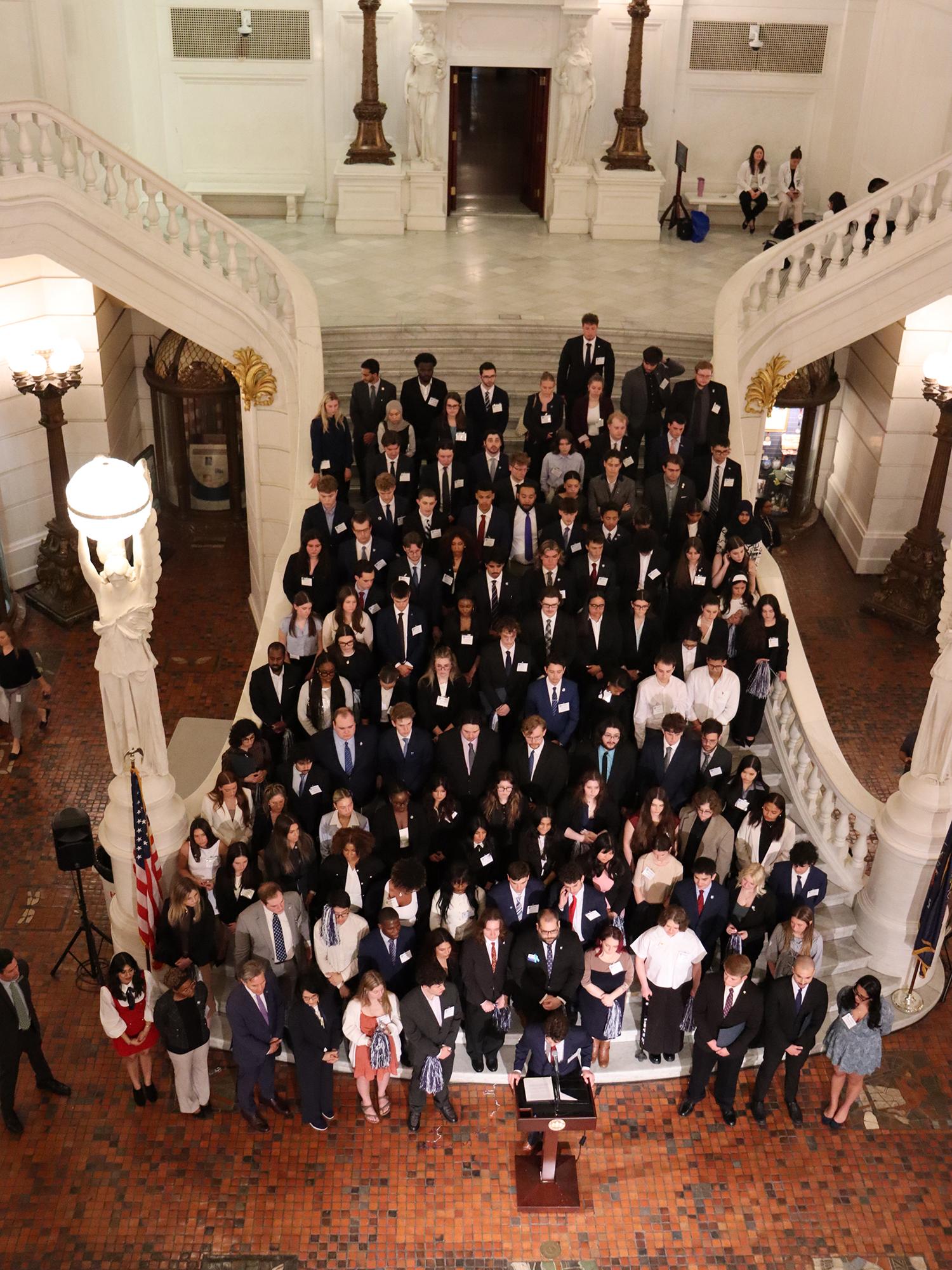 A large group of people on a marble staircase.