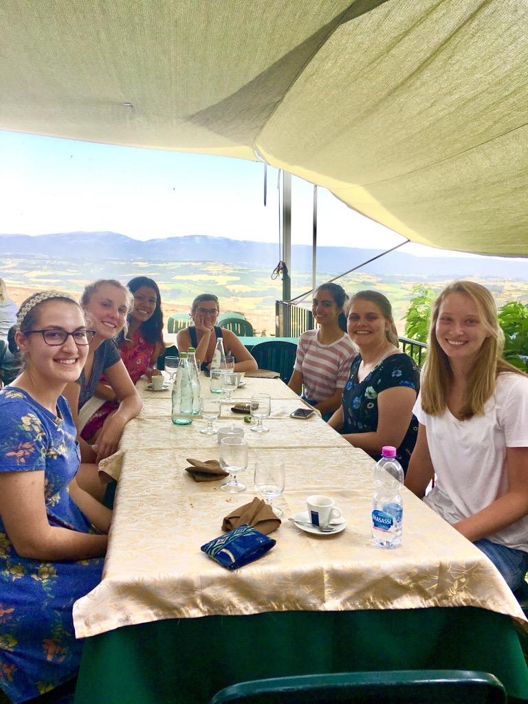 A group photo of students smiling around a table.