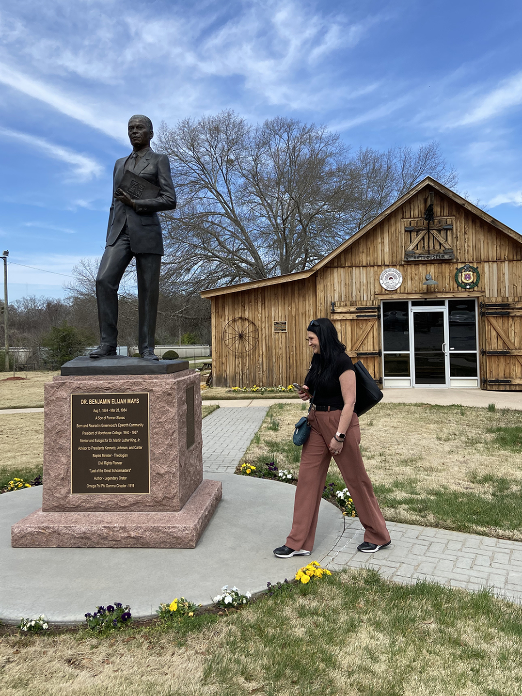 A woman walking in front of a monument.