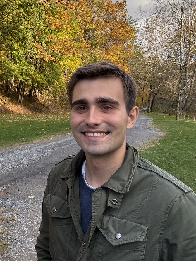 Headshot of a student in front of fall foiage