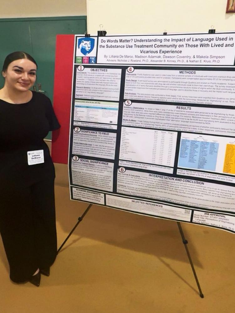 Lilliana Demarco standing in front of her research poster