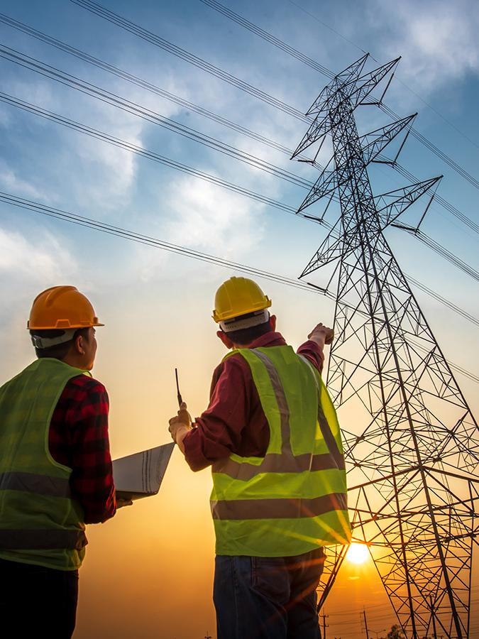 two people look at a transmission tower in the distance