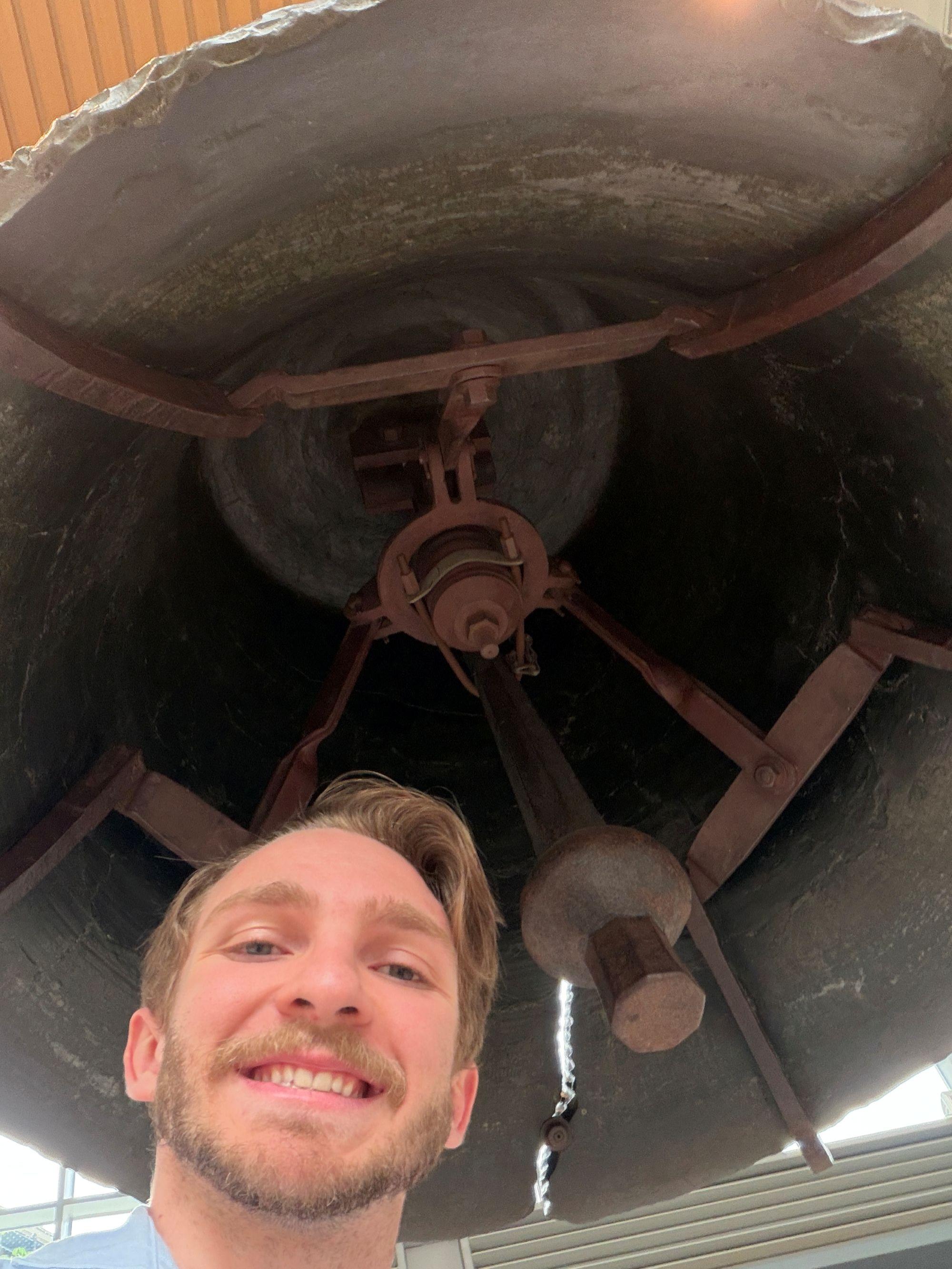 Penn State Behrend alumnus Remington Orange poses beneath the Liberty Bell during a two-day research trip.