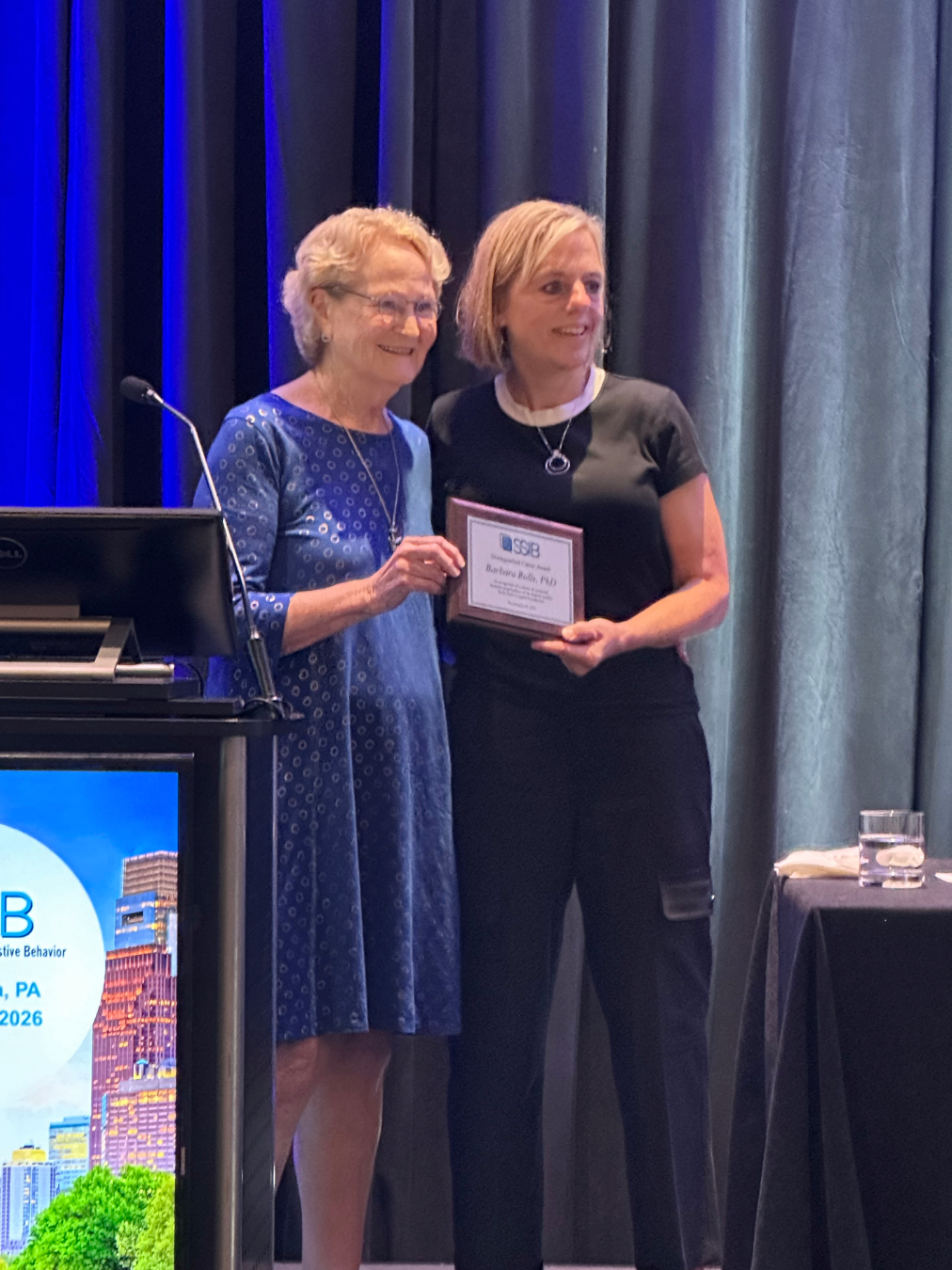 Barbara Rolls is pictured with Kathleen Keller on a stage receiving an award