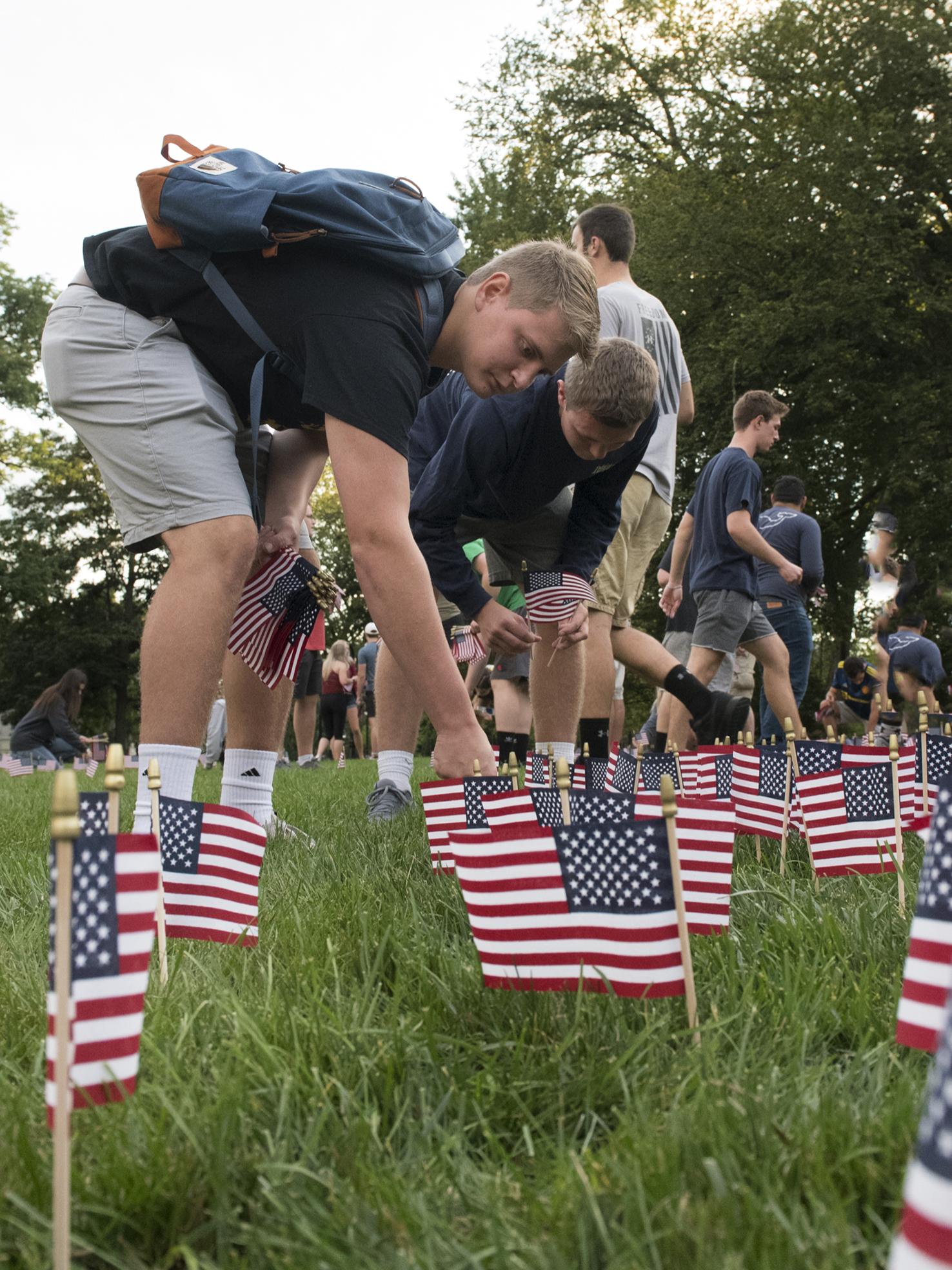 students placing flags on lawn