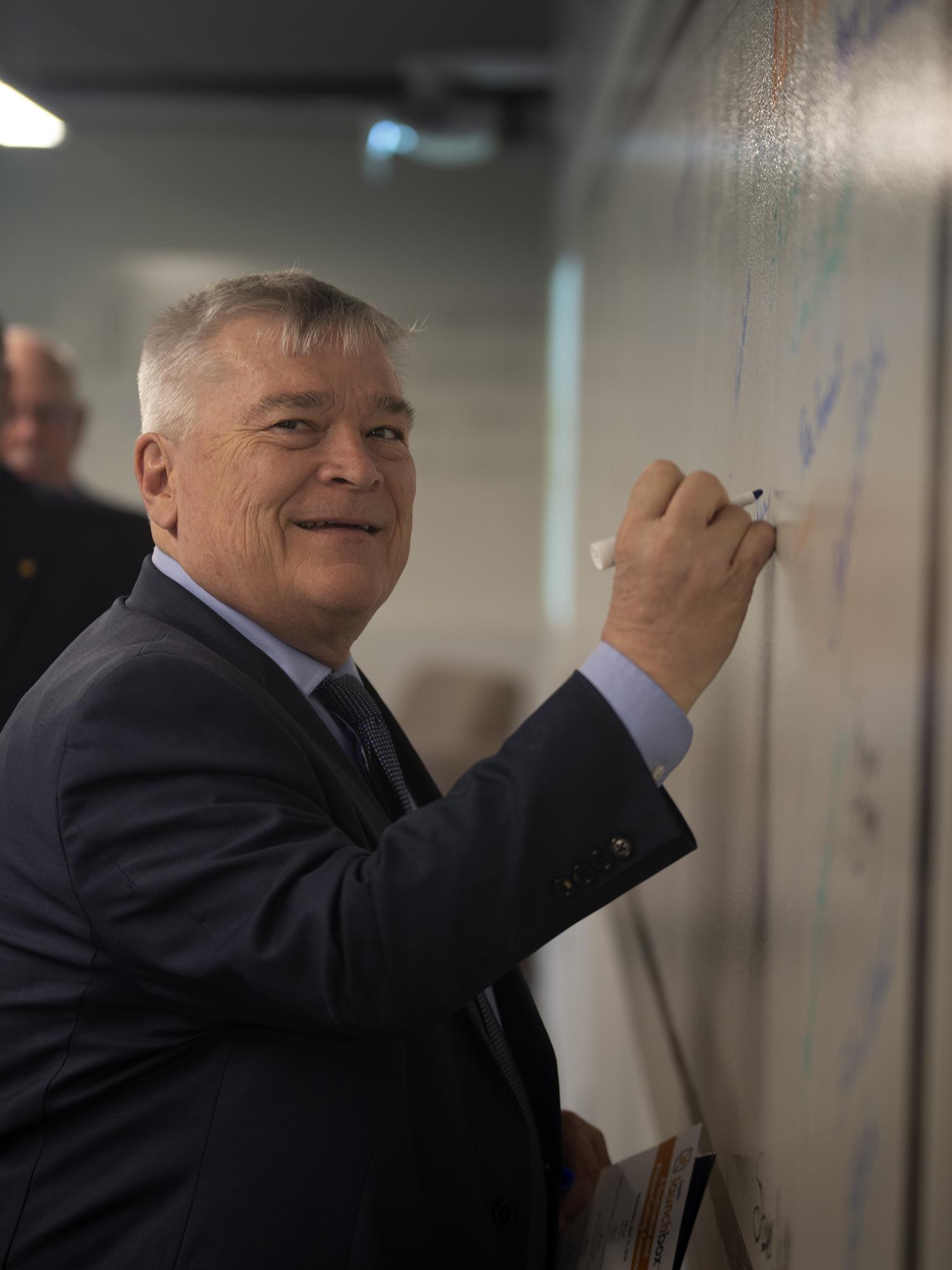 Dr. Eric Barron signs the Fayette LaunchBox wall of fame.