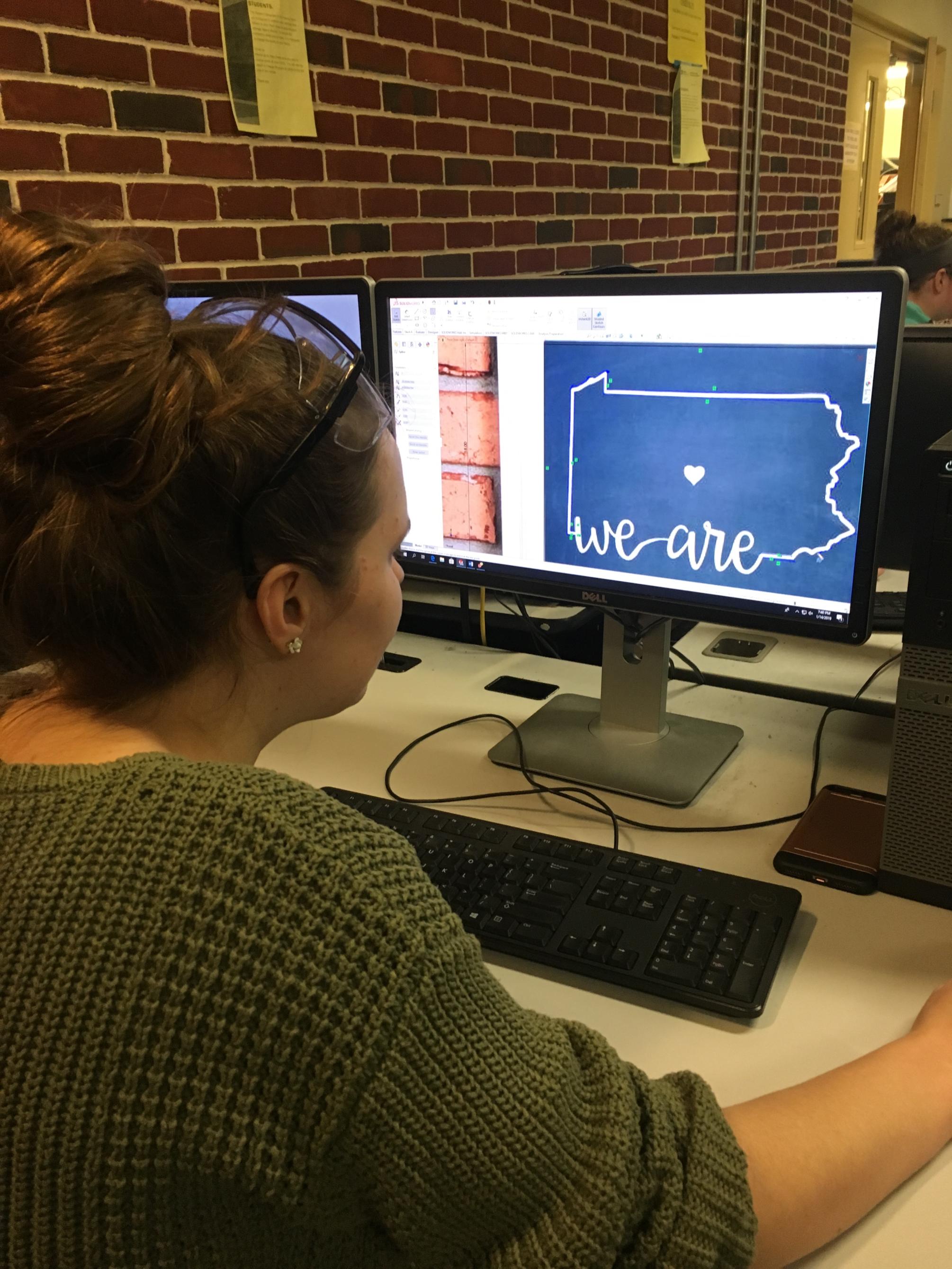 Female student sitting at computer working on design