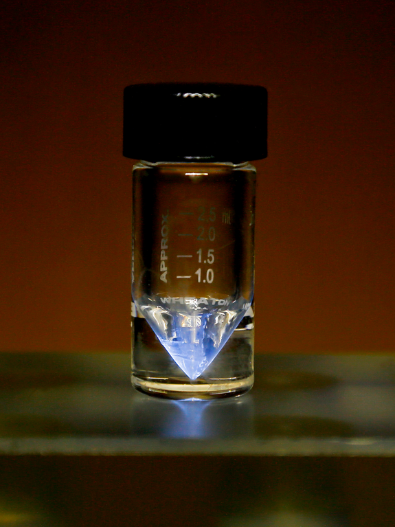 vial with actinium that is glowing blue