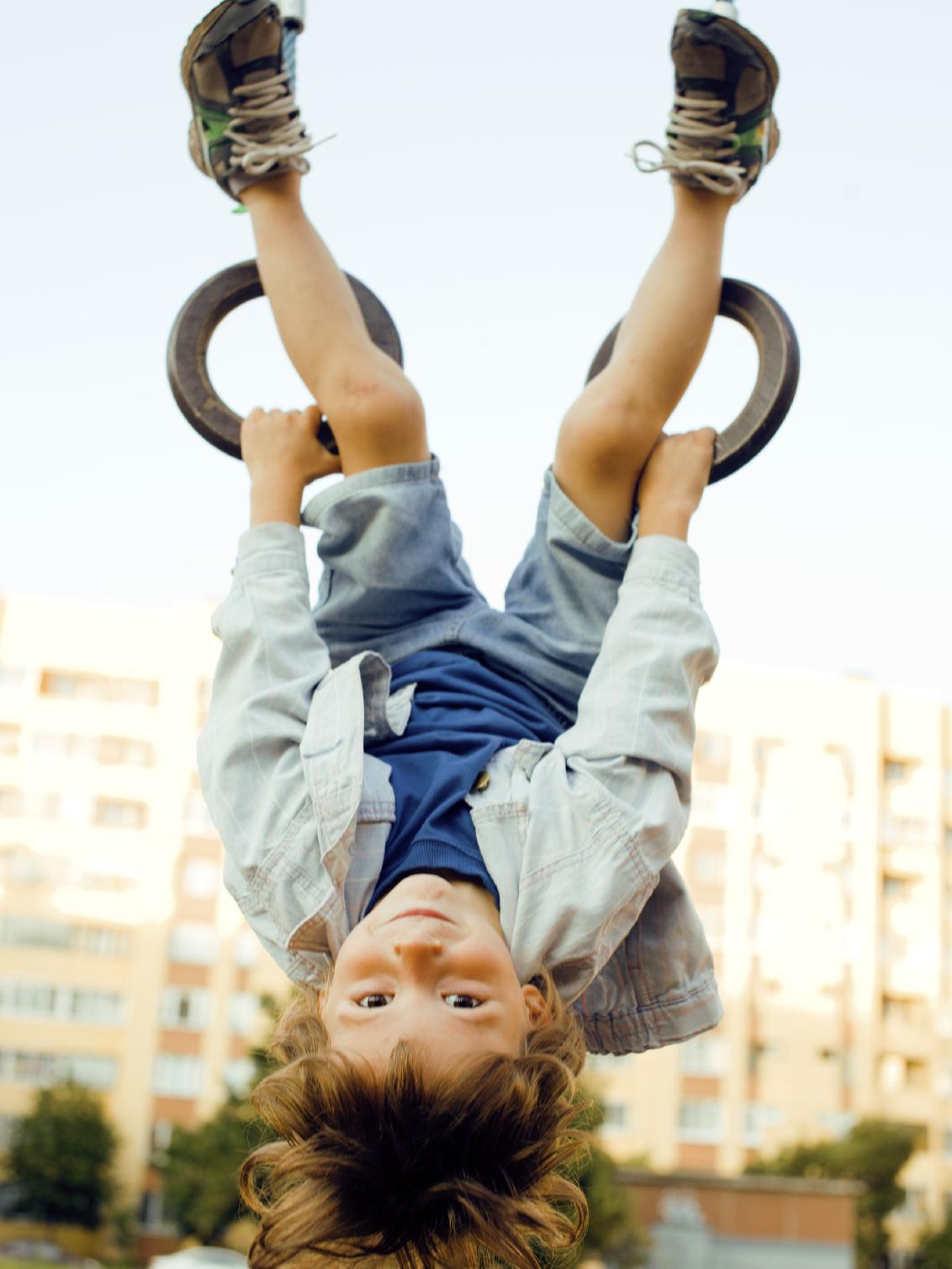 Child hangs on the rings at a playground 