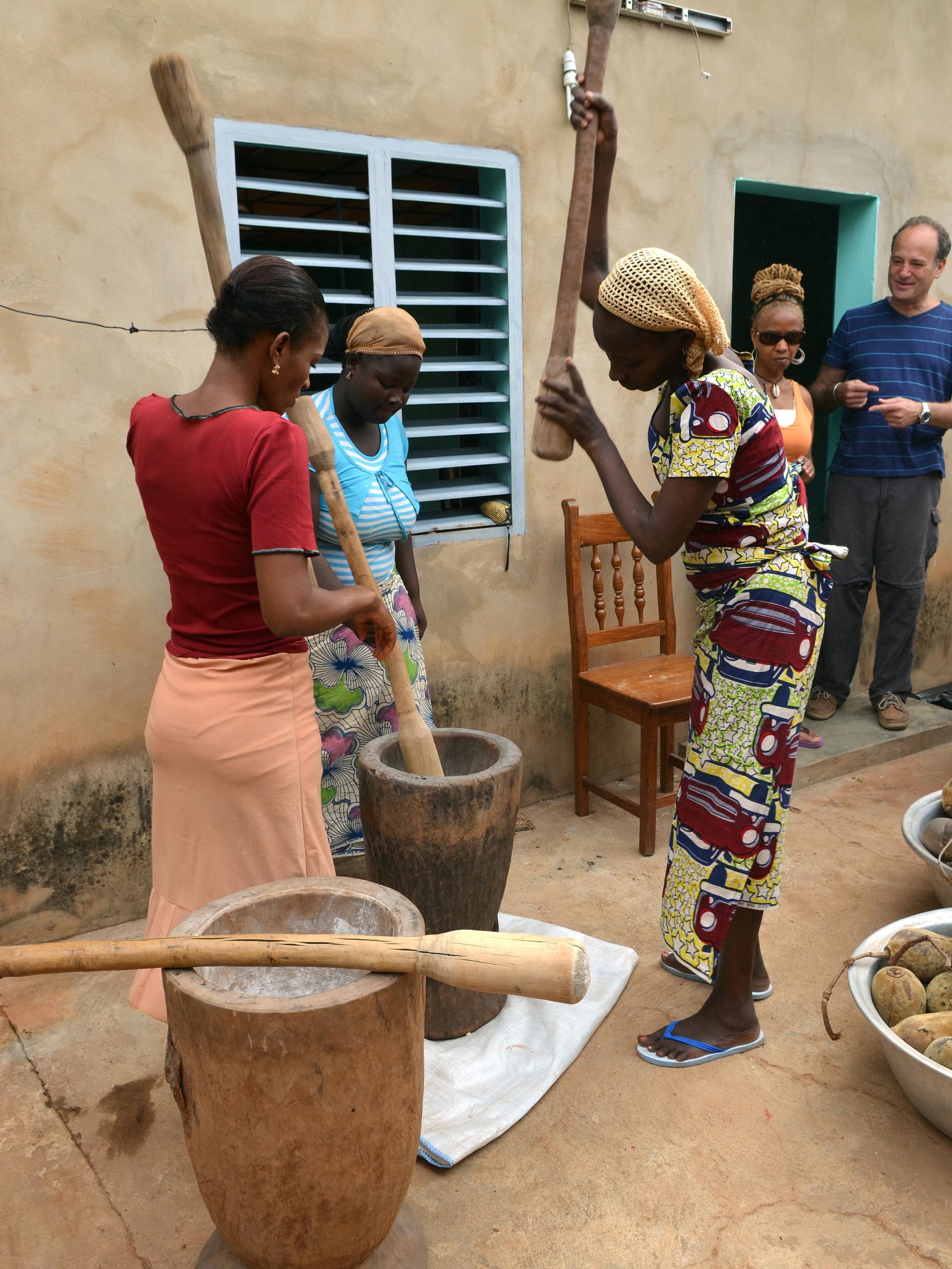 Women pound baobab pulp with giant mortar and pestles