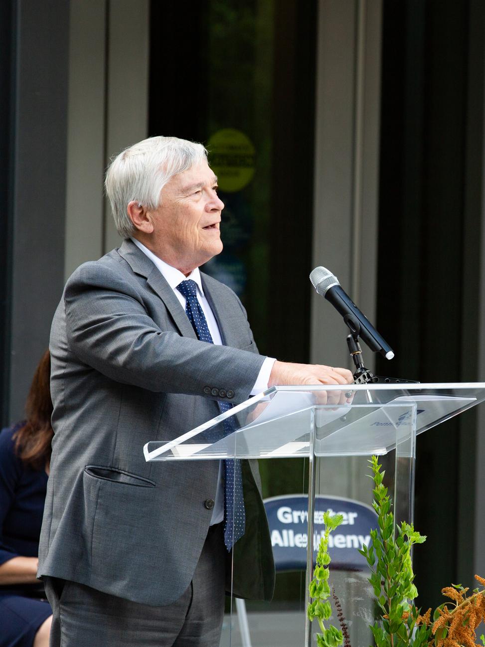 President Barron speaking at a podium into a microphone