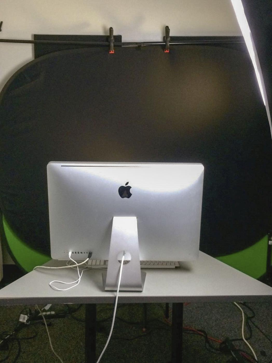Computer in front of a black background lit from the side