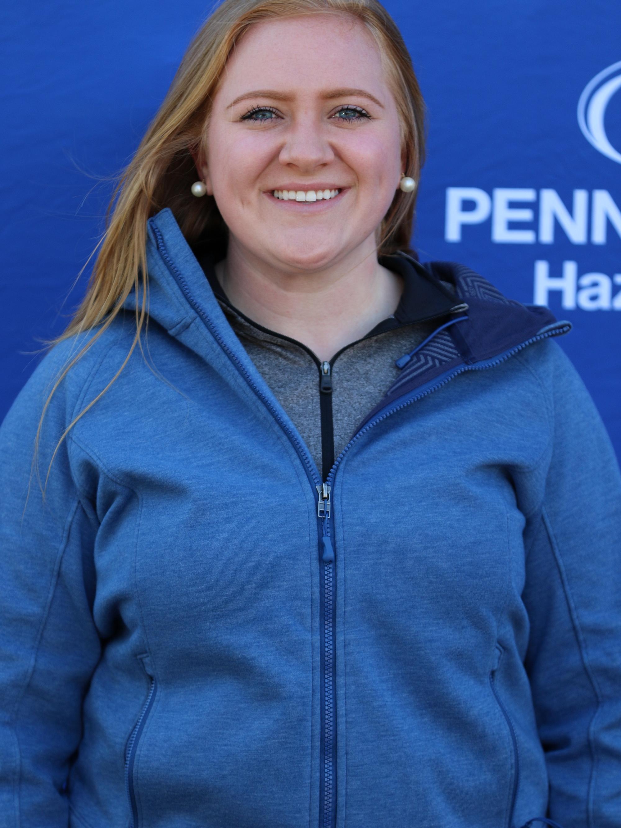 Penn State Hazleton Athletic Trainer Megan Bobish wearing blue windbreaker in front of Penn State Hazleton backdrop