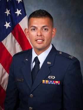 Air Force major in uniform poses for headshot photo in front of USA flag