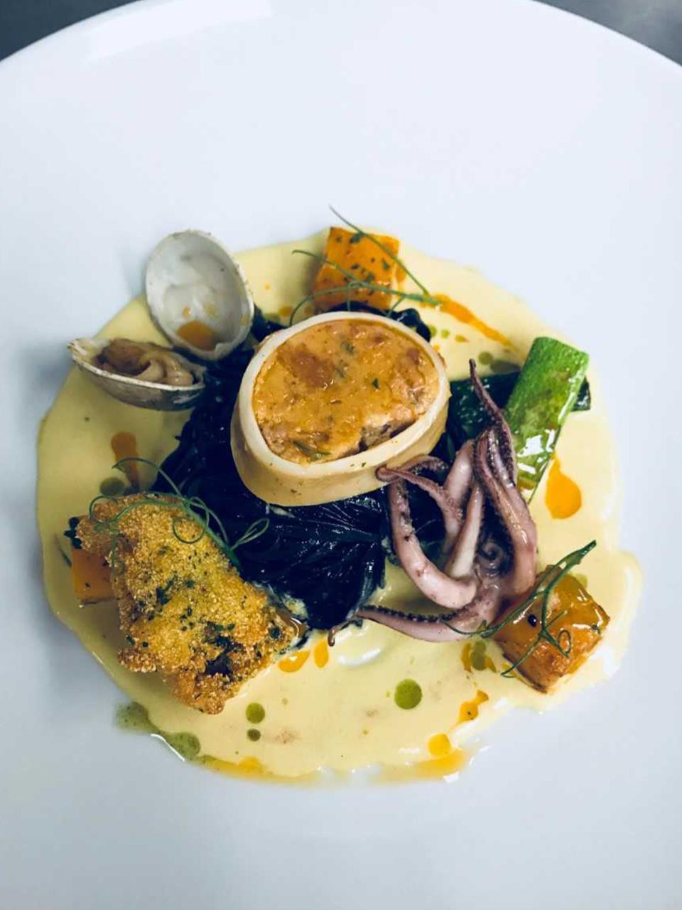 squid ink pasta with crispy Rhode Island oyster, poached squid sausage, sautéed curry clam, batonnet zucchini, and pan roasted butternut squash in a saffron cream sauce 