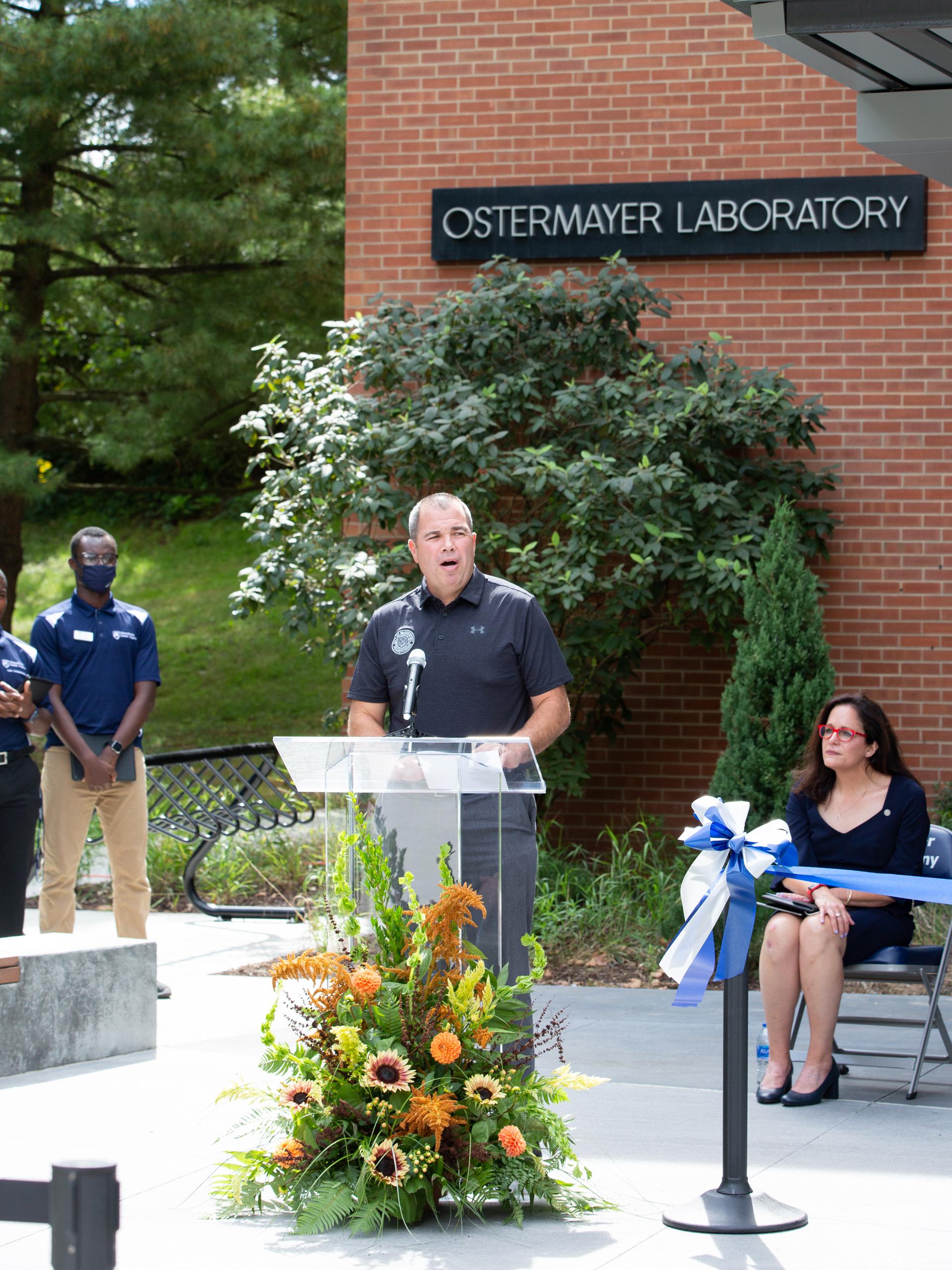 Man standing behind podium and talking into a microphone