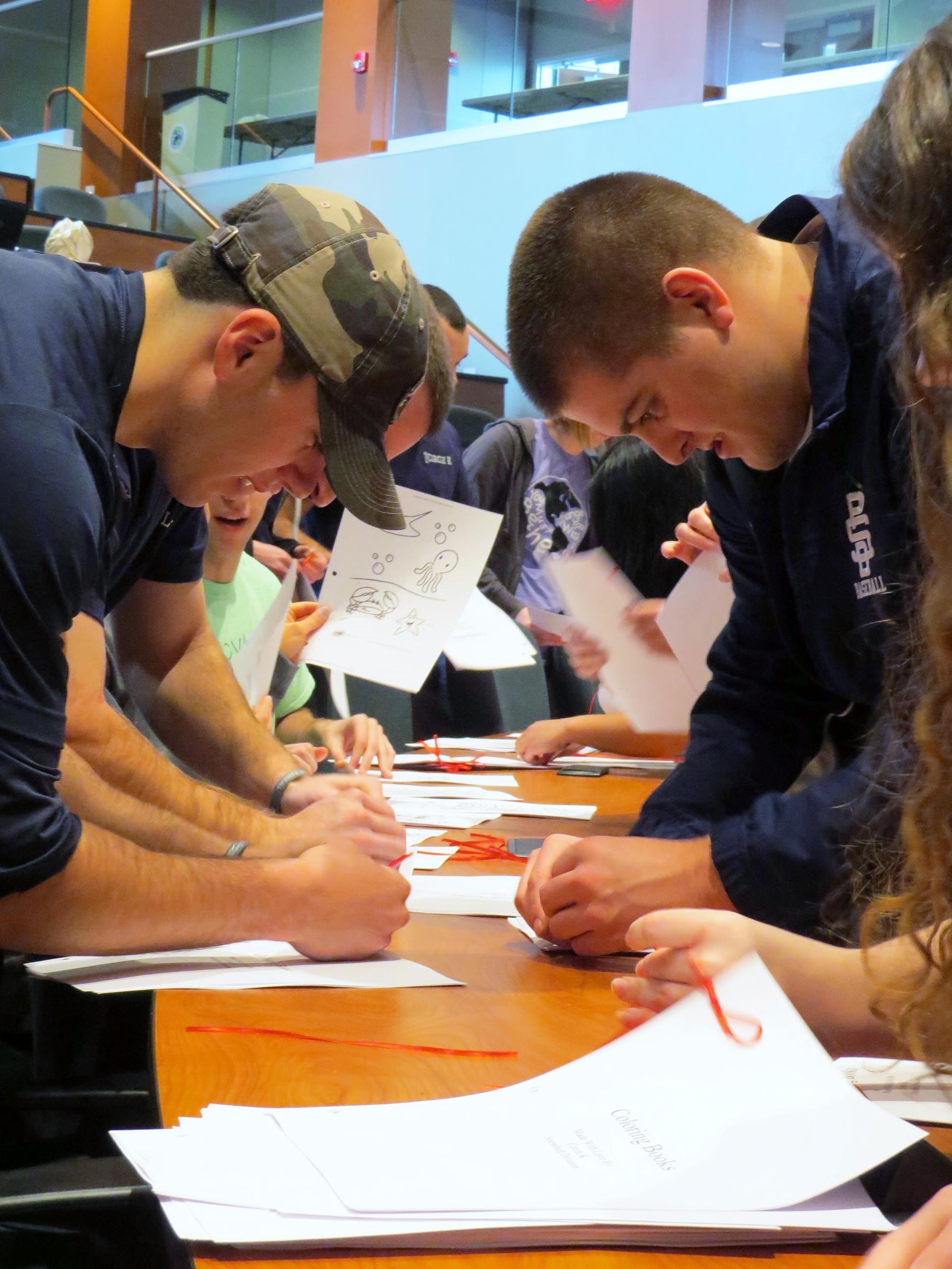 Students assemble coloring books during a service project at Penn State Behrend.