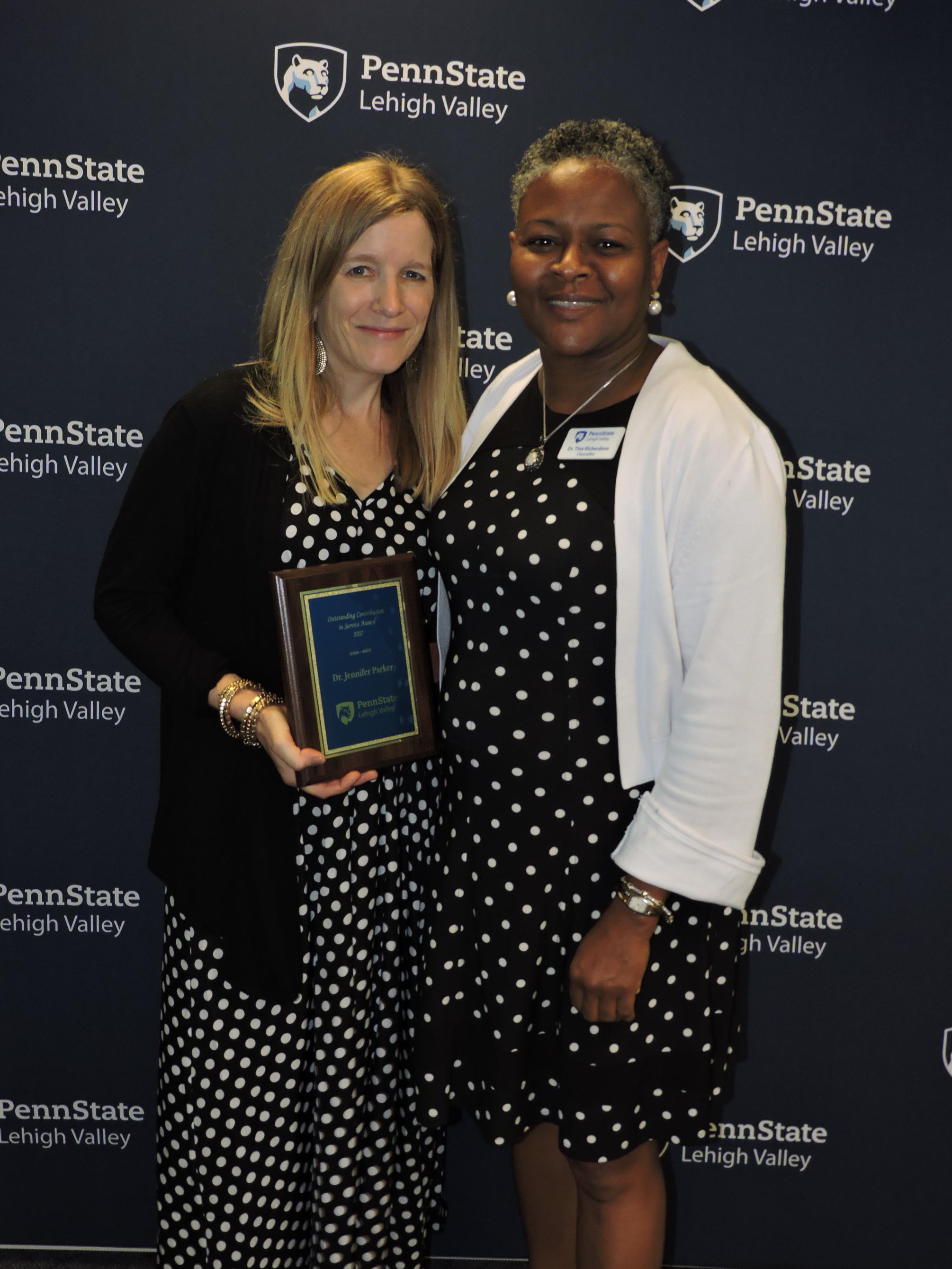 two women holding an award