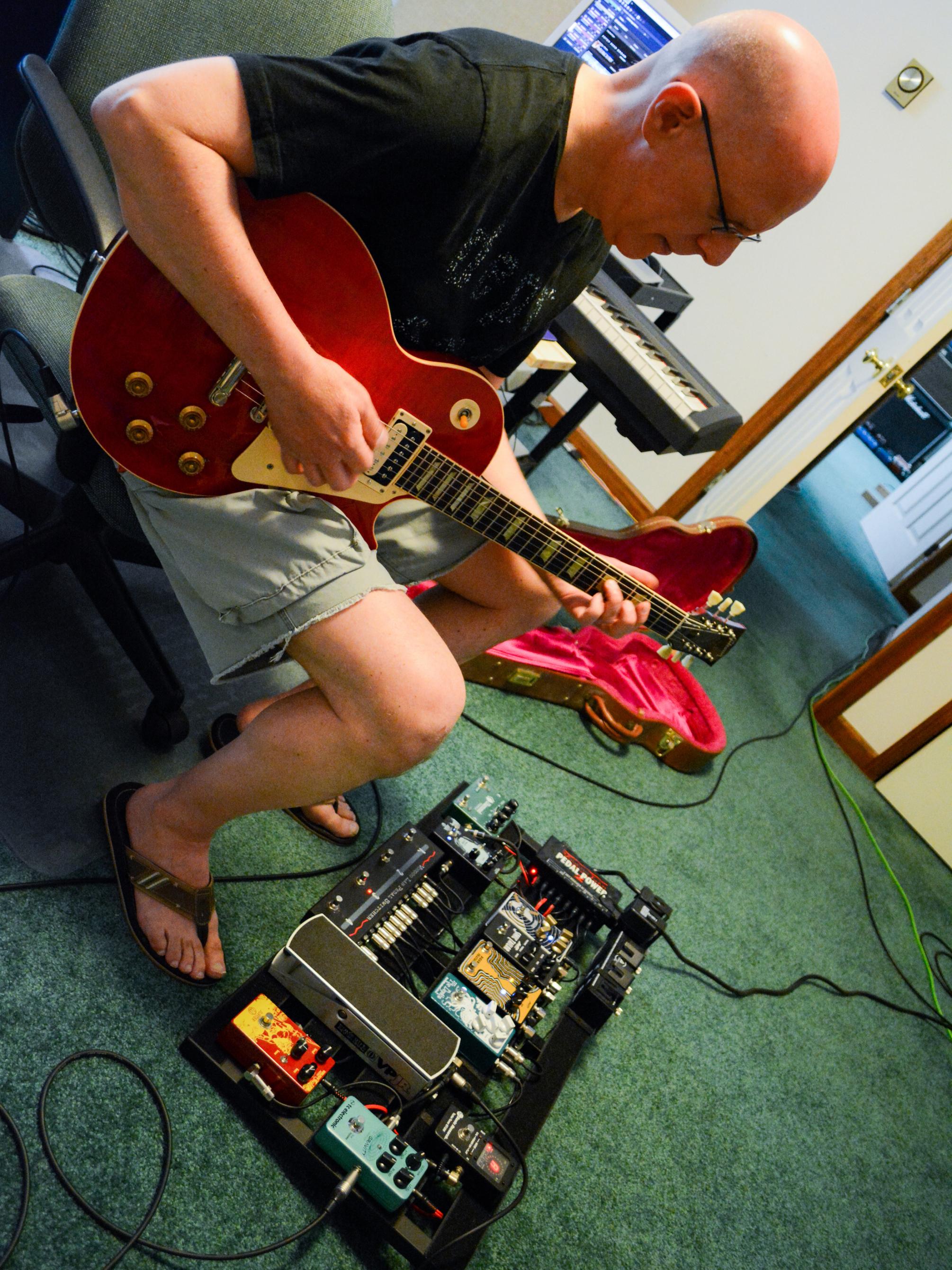 Bob Klotz plays guitar in his studio.